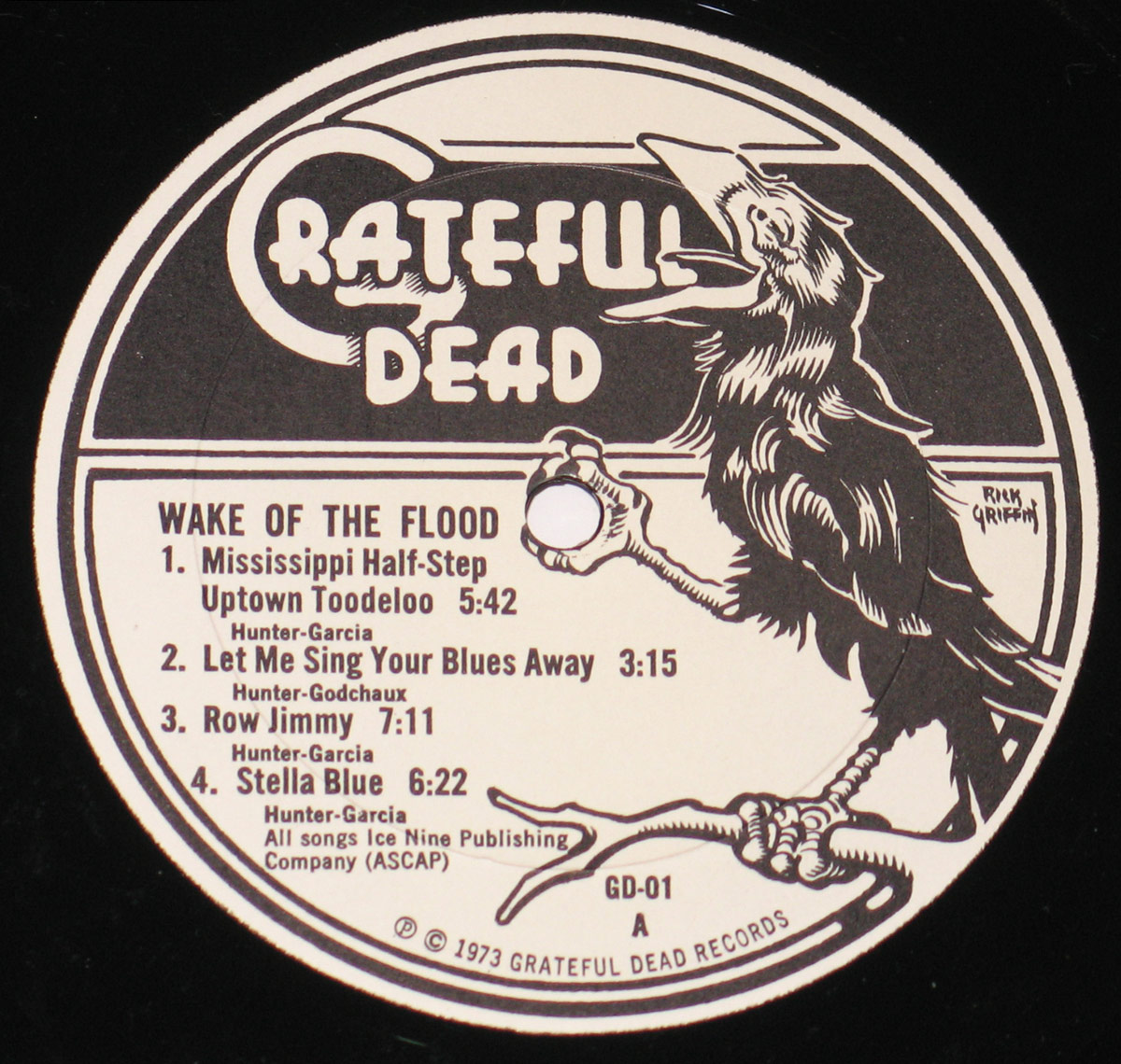 Wake of the Flood record label featuring a monochromatic illustration of a raven perched on a branch, beak open in mid-call, with 'Grateful Dead' written in a stylized, dripping font. The track listing is printed below, framed within a bold circular border.