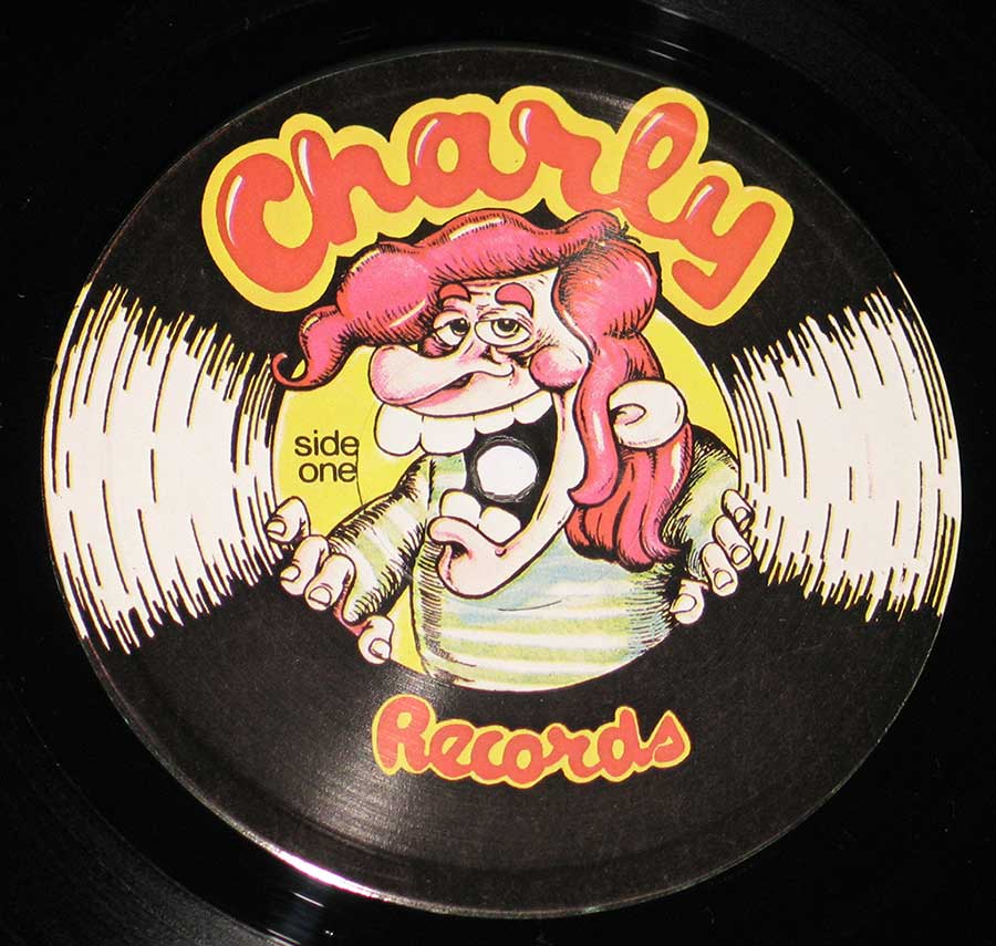 ‘Charly Records label featuring a cartoon character with pink hair holding records to each ear, with a humorous expression, surrounded by bold text “Charly Records” in retro red and yellow font.’