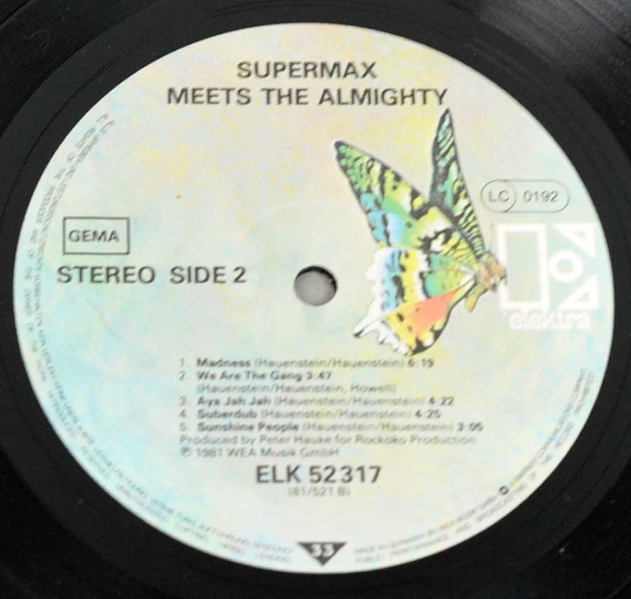 Close-up of Side Two record label from 'Supermax - Meets Almighty'. Displays Elektra's butterfly logo on a soft cloud-like background, with black text listing track names, durations, and catalog number ELK 52317. 'Stereo Side 2' and the GEMA rights society logo are printed on the left side.