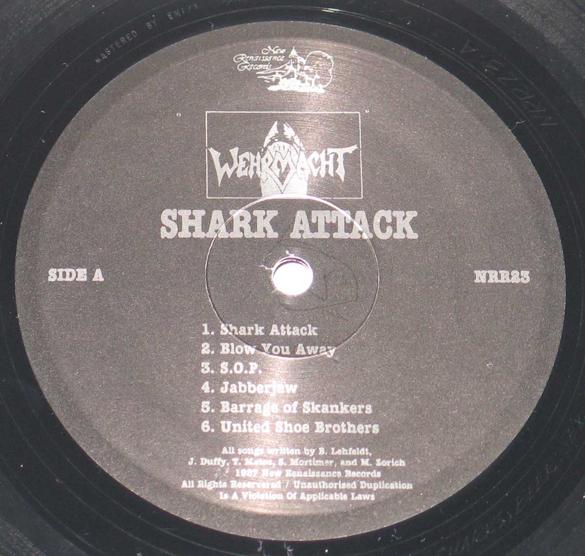 Vinyl label of Wehrmacht’s Shark Attack album Side A, featuring the band logo, shark emblem, tracklist, and New Renaissance Records branding.