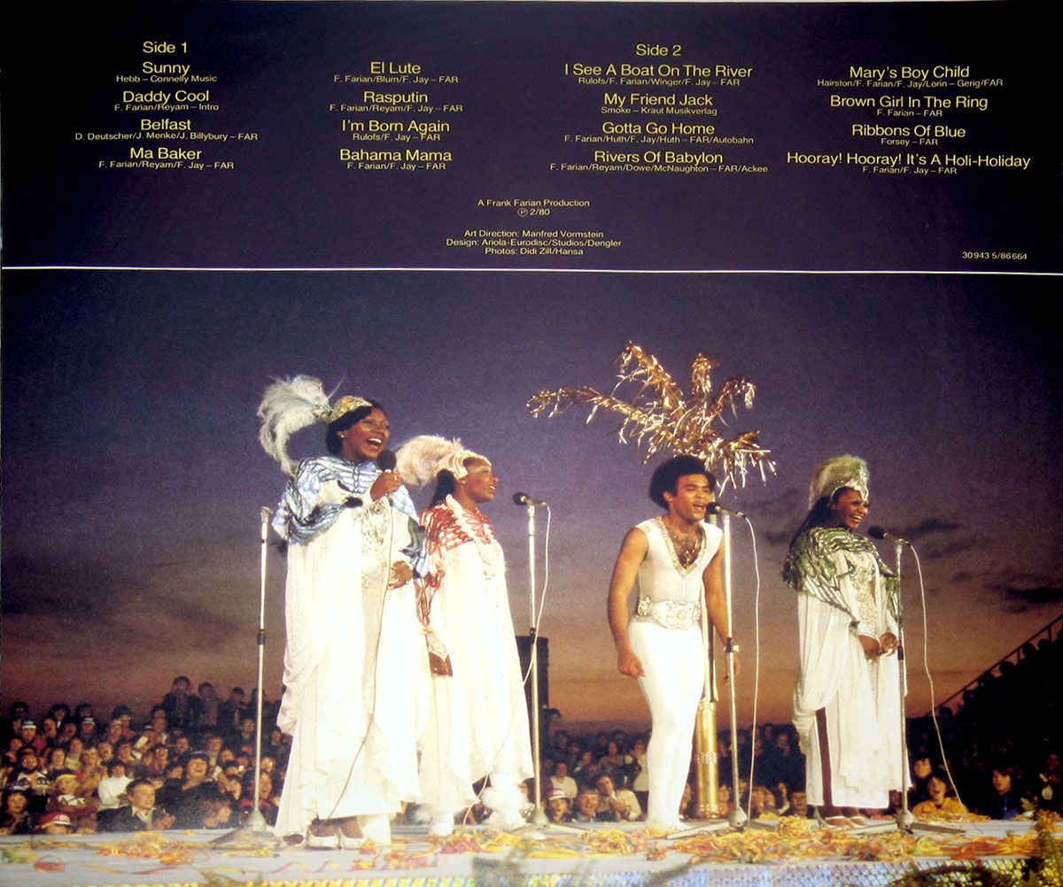 Boney M performing live in elaborate costumes with feathers and glitter, set against a sunset backdrop and a cheering audience on the album's back cover