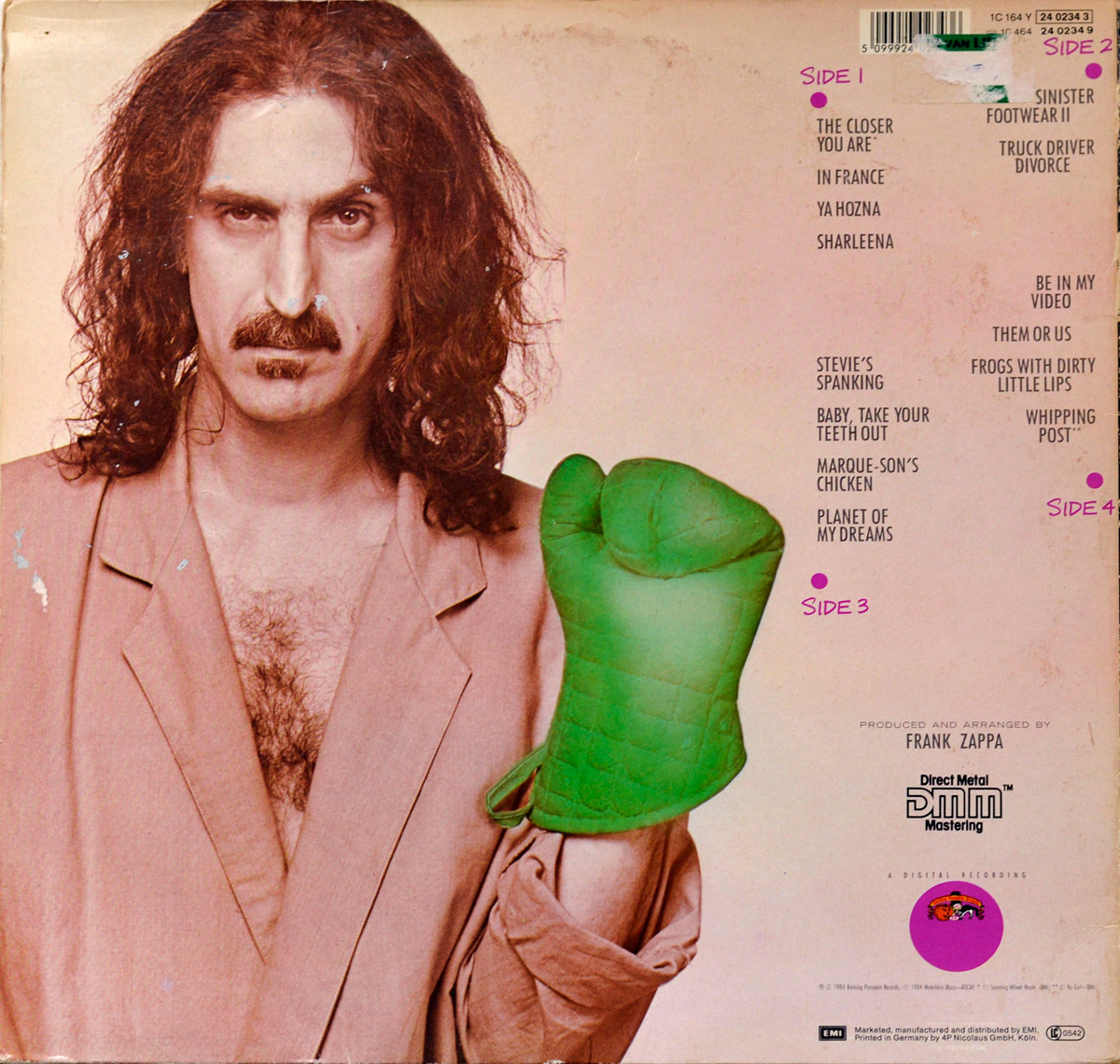 Back cover of Frank Zappa's 'Them Or Us' album. It features a sepia-toned photograph of Frank Zappa with shoulder-length curly hair, a mustache, and a serious expression. He is wearing a loose-fitting beige robe, exposing part of his chest. His right hand is raised, wearing an oversized green oven mitt in the shape of a fist. The tracklist is printed on the right side in a simple black font, divided into four sides, with each side marked by a magenta dot. The bottom section includes production credits, the Direct Metal Mastering (DMM) logo, and a small circular illustration of a cartoonish face.