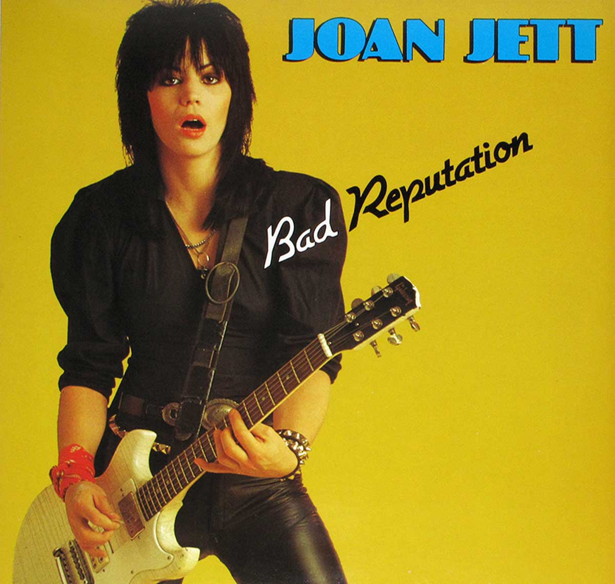 Joan Jett's Bad Reputation album cover, featuring her holding an electric guitar against a yellow background with bold text