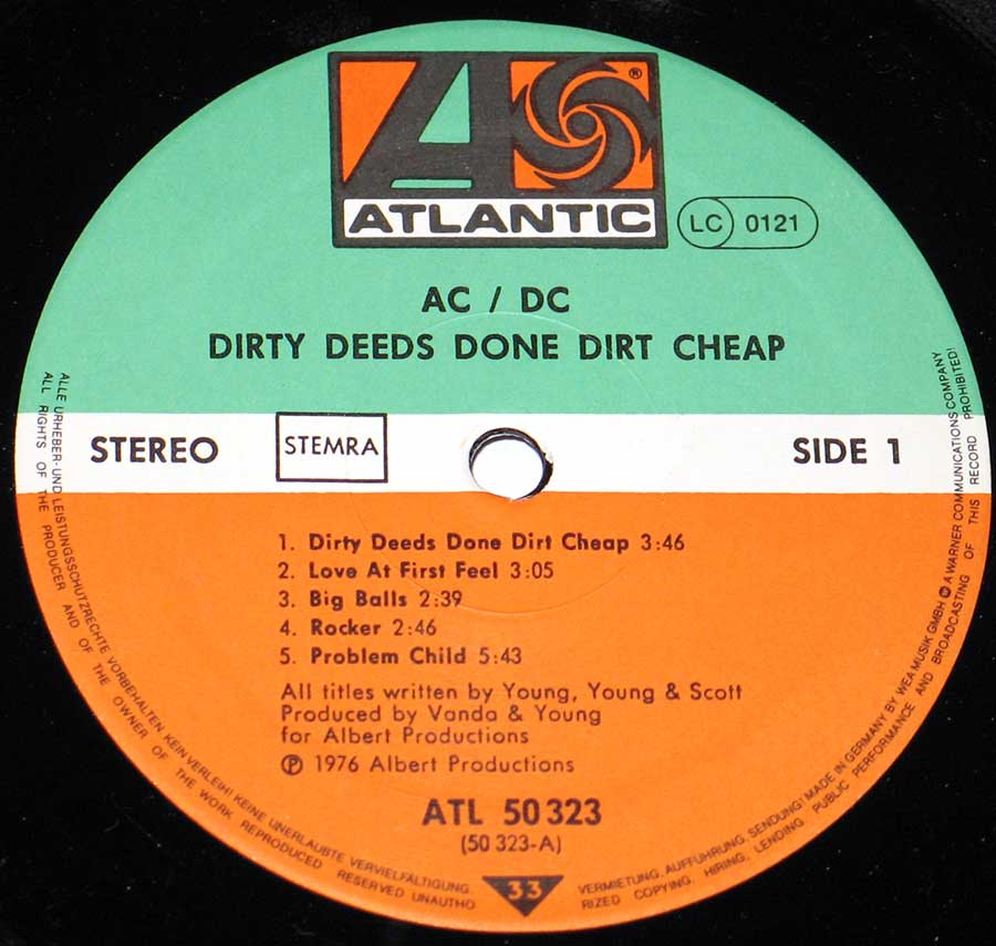 AC/DC Dirty Deeds Done Dirt Cheap Side 1 record label. Features the classic Atlantic Records design with a green top section, white middle band, and orange bottom section. The Atlantic logo is at the top, followed by the artist name, AC/DC, and album title. The white band includes “STEREO” on the left, “STEMRA” in a box, and “SIDE 1” on the right. The orange section lists the track titles: Dirty Deeds Done Dirt Cheap, Love at First Feel, Big Balls, Rocker, and Problem Child. Credits mention songwriters Young, Young & Scott, and producers Vanda & Young for Albert Productions, with catalog number ATL 50323 at the bottom.