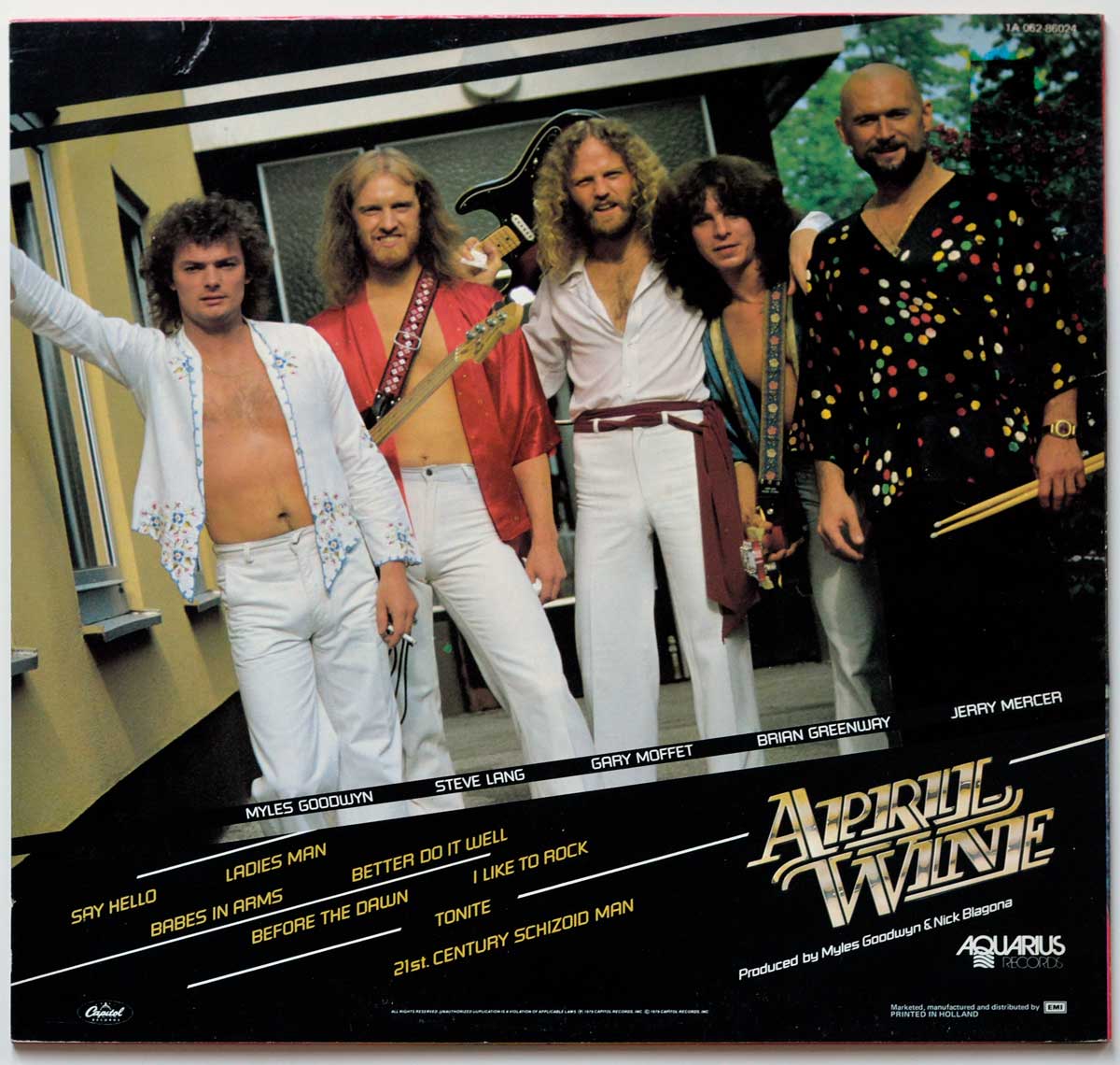 Back cover of April Wine's Harder... Faster album featuring a photo of the band members. From left to right: Myles Goodwyn in a white floral outfit holding a guitar, Steve Lang in a red shirt with a bass guitar, Gary Moffet in white with a burgundy sash, Brian Greenway in a deep-necked blue top with a guitar strap, and Jerry Mercer in a black shirt with multicolored polka dots holding drumsticks. The scene is set outdoors near a modern building.