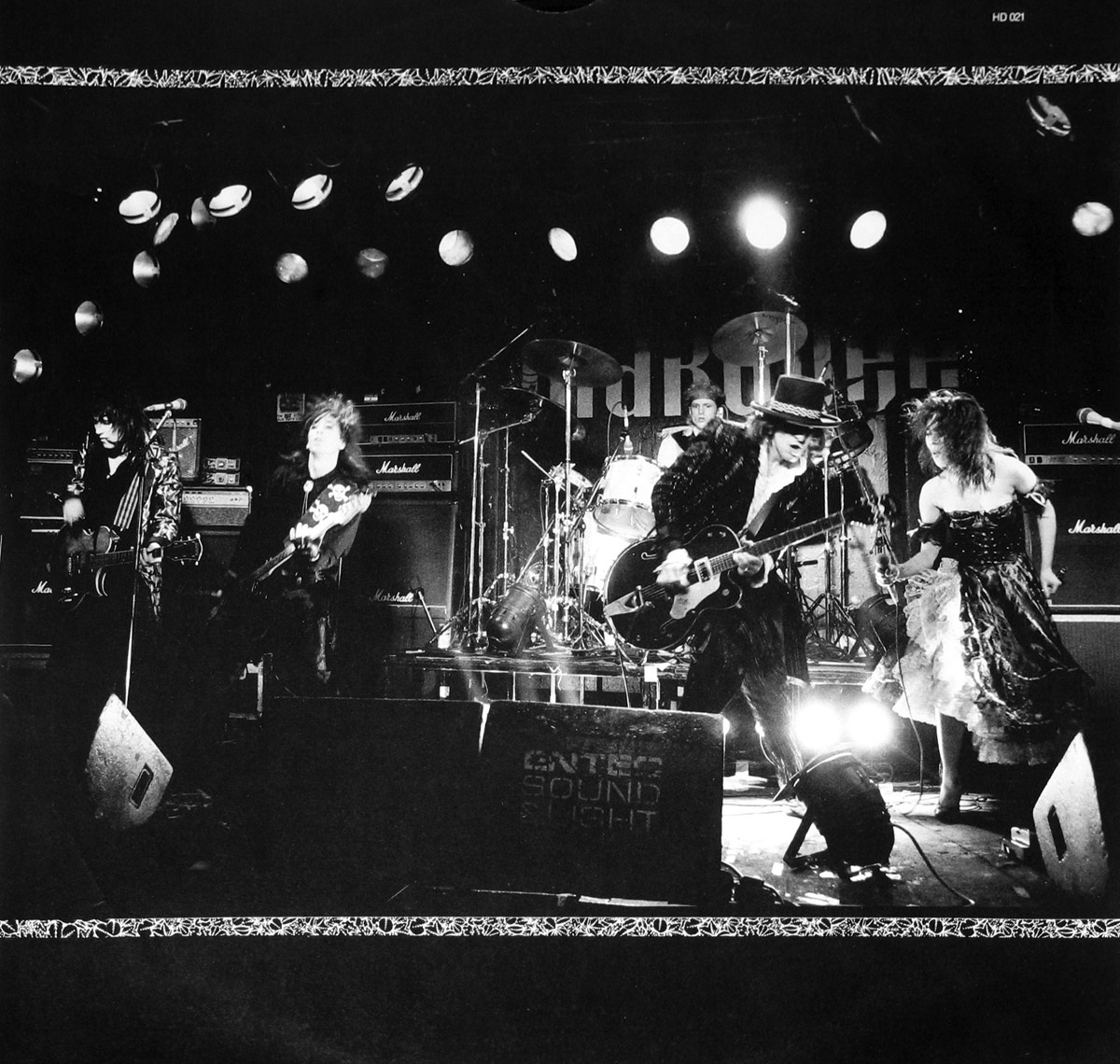 Black-and-white live concert photo of Cherry Bombz on stage at the Marquee Club, showing all band members mid-performance with instruments and dramatic lighting.