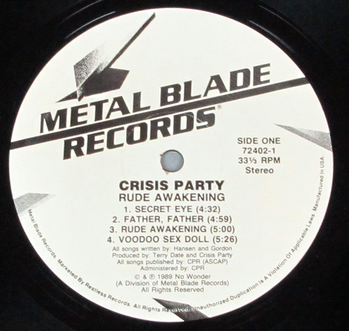 Close-up of the Side One record label of CRISIS PARTY's 'Rude Awakening' album. The label is white with bold black text featuring the 'Metal Blade Records' logo at the top, which includes a stylized metallic blade. The tracklist for Side One is centered, listing four songs with their durations. Below, production credits mention Terry Date and Crisis Party. Additional small print details publishing rights and distribution under Metal Blade Records.
