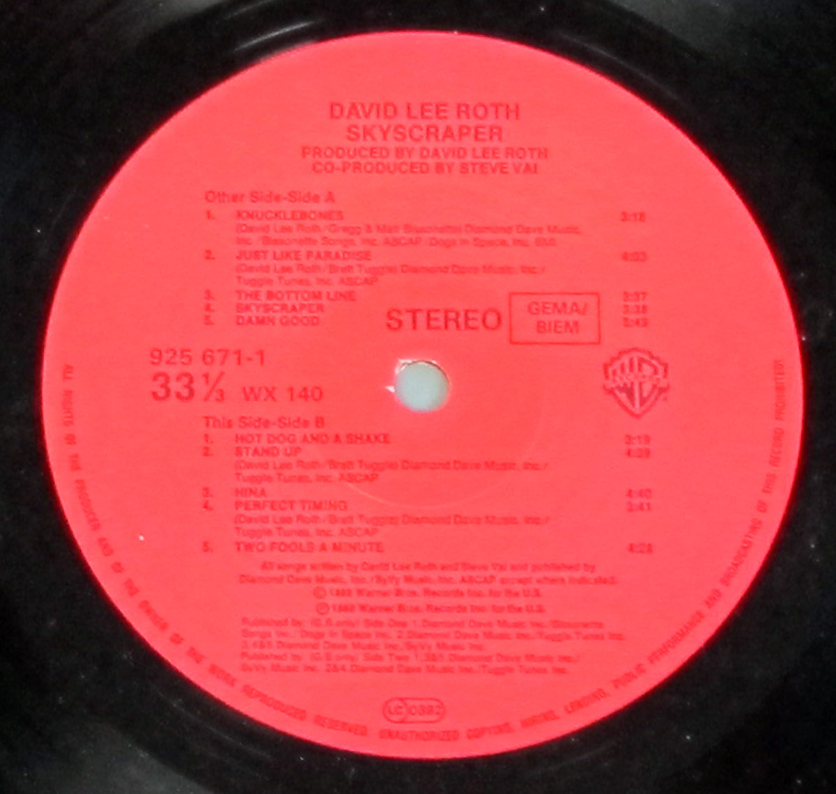 Red vinyl label for David Lee Roth's Skyscraper album showing tracklist for both sides A and B, production credits, catalog numbers, and logos including Warner Bros. and GEMA/BIEM.