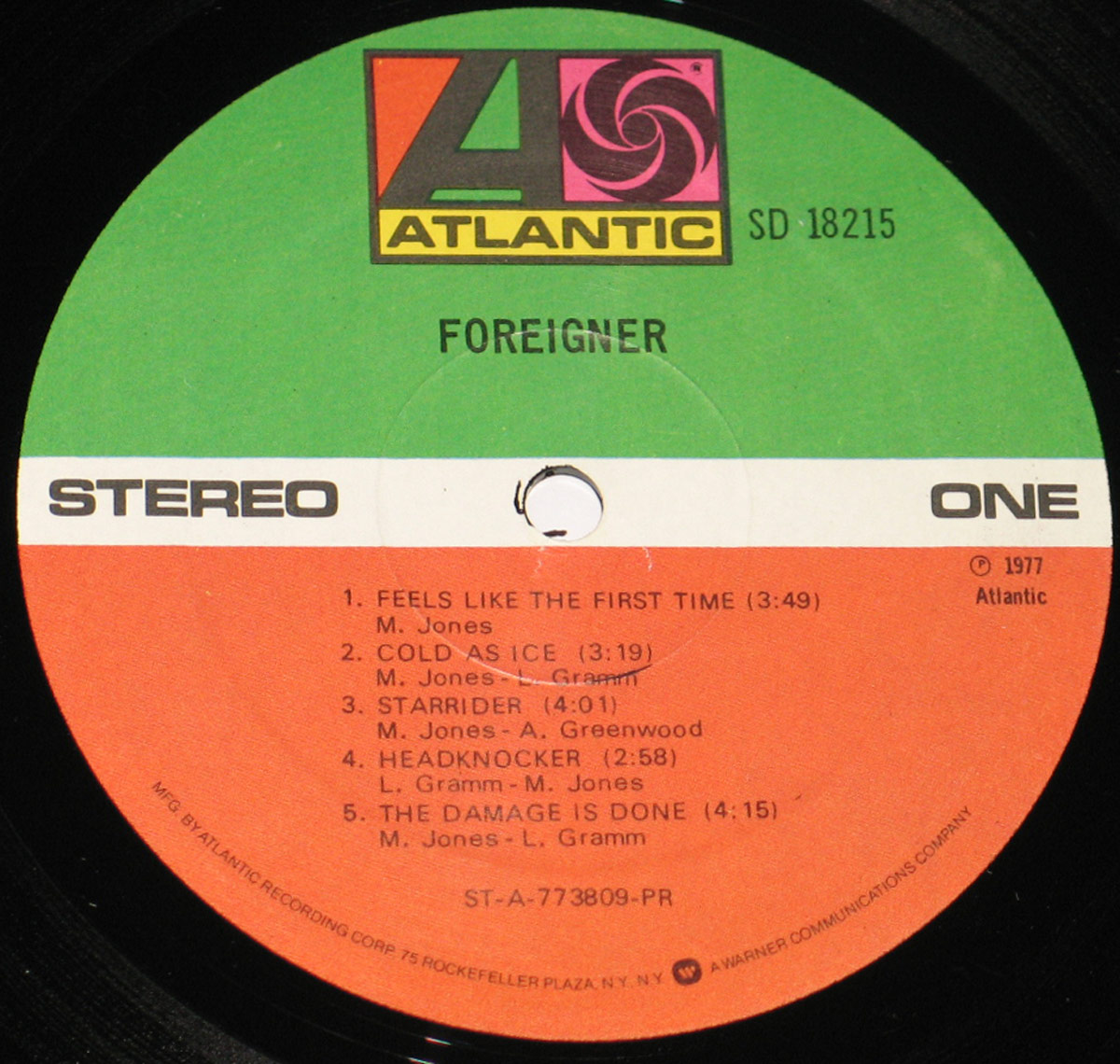 Side One label of Foreigner's 1977 self-titled vinyl album, showing Atlantic Records green-white-orange design, tracklist, credits, and catalog number SD 18215.