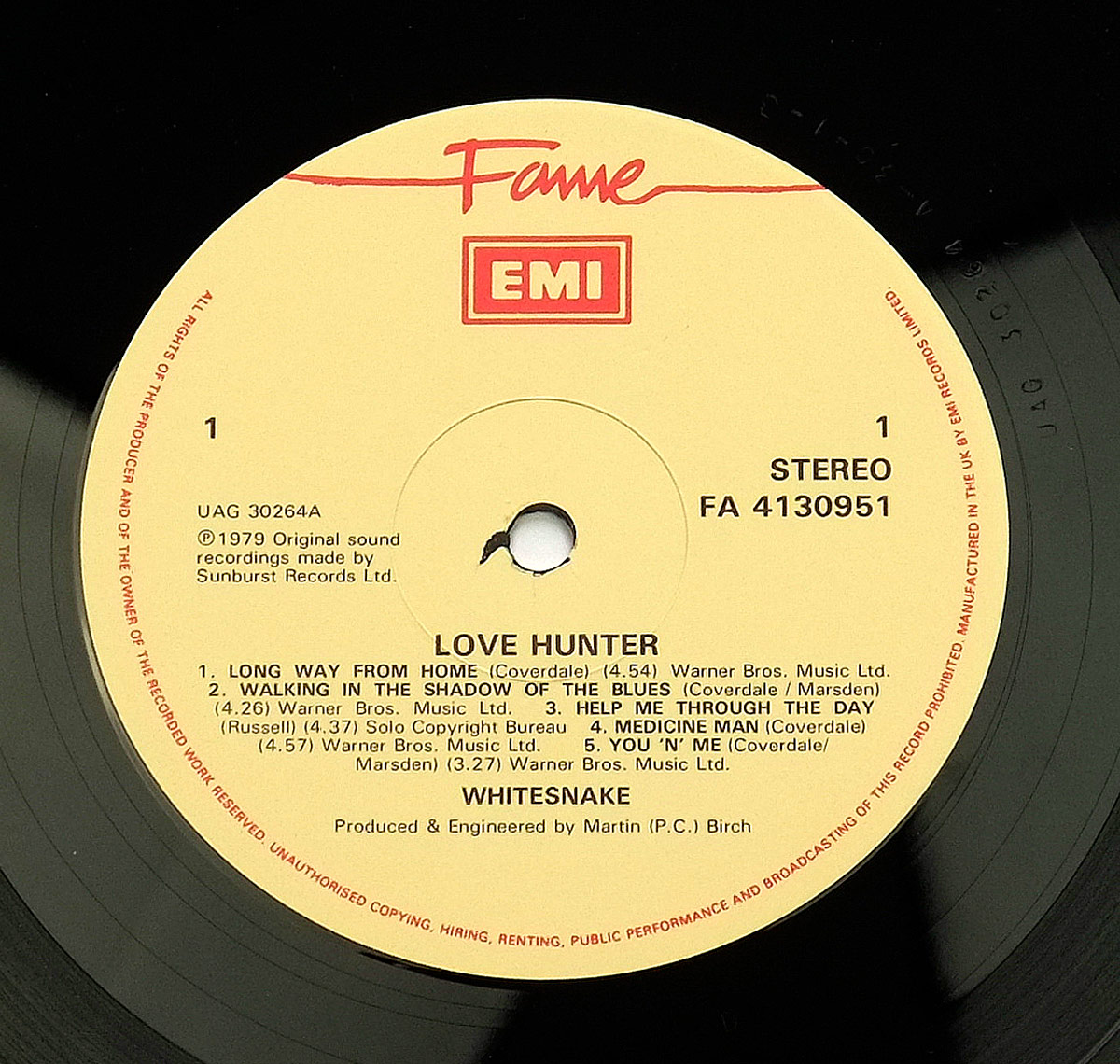 Close-up of Side One record label for Whitesnake's 1979 album Lovehunter. The label is cream-colored with a red Fame logo at the top and EMI boxed beneath it. Around the outer edge, small red text reads 'All rights of the producer and of the owner of the recorded work reserved.' The catalog number UAG 30264A is printed on the left, with FA 4130951 and Stereo designation on the right. The track listing for Side One is centered below the title Love Hunter, listing songs including Long Way From Home, Walking in the Shadow of the Blues, Help Me Through the Day, Medicine Man, and You 'N' Me. At the bottom, production credit notes Martin (P.C.) Birch as producer and engineer, with copyright ©1979 Sunburst Records Ltd.