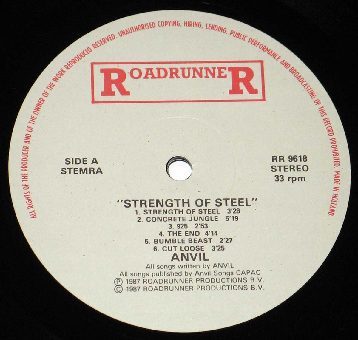 Close-up of the vinyl record label for Anvil's 'Strength of Steel' album. The label is white with red and black text, featuring the 'Roadrunner Records' logo at the top and listing the six tracks on Side A along with production details. The record's hole is visible in the center.