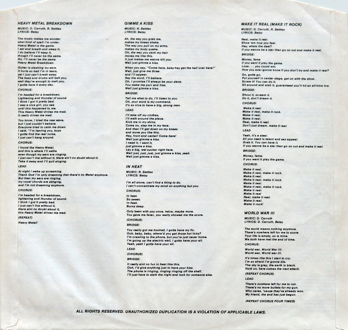 Lyrics sheet of BITCH - Be My Slave album. A black-and-white printed inner sleeve featuring song lyrics for tracks like 'Heavy Metal Breakdown,' 'Gimme A Kiss,' 'Make It Real (Make It Rock),' 'In Heat,' and 'World War III.' The text is arranged in neat columns, with songwriting credits for music and lyrics.