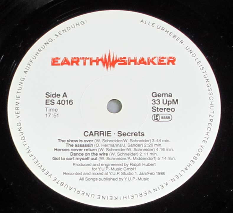 Record label of Carrie’s Secrets album with a white background, the red Earthshaker logo at the top, catalog number ES 4016, 33 RPM Stereo, GEMA logo, and copyright text in German around the outer edge