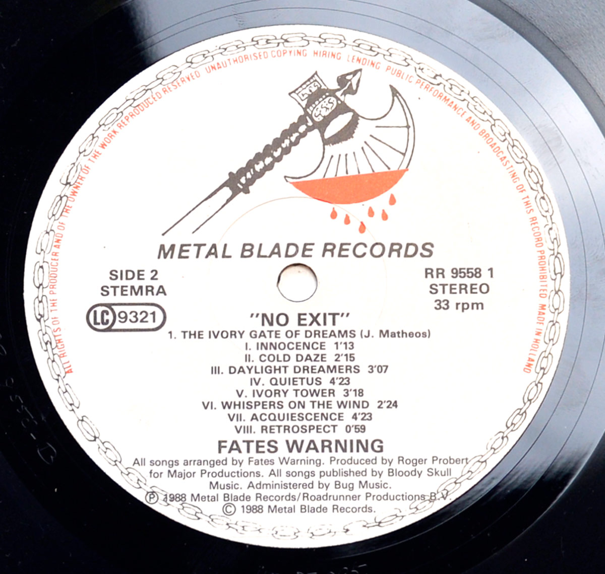 Close-up of Side Two of Fates Warning's 'No Exit' vinyl LP, featuring the Metal Blade Records label with the 'Blood Dripping Axe' logo. This side contains 'The Ivory Gate of Dreams,' a multi-part epic divided into eight movements: Innocence, Cold Daze, Daylight Dreamers, Quietus, Ivory Tower, Whispers on the Wind, Acquiescence, and Retrospect. The label also includes copyright details, production credits, and the publishing information for Bloody Skull Music.