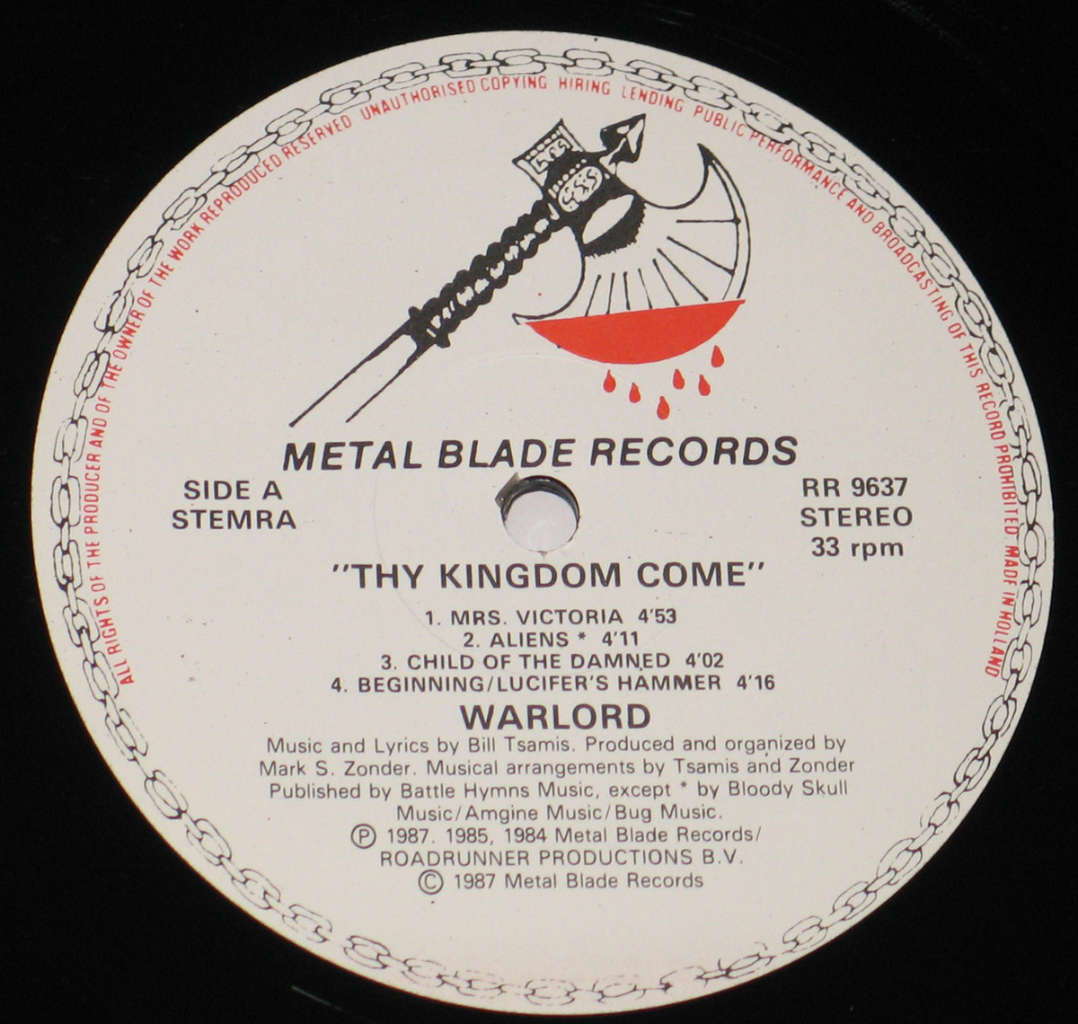 Close-up of the record label for 'Thy Kingdom Come' by Warlord on Metal Blade Records, featuring the iconic blood-dripping axe logo. The label displays the tracklist for Side A, including 'Mrs. Victoria,' 'Aliens,' 'Child of the Damned,' and 'Beginning/Lucifer’s Hammer.' Additional text provides copyright details, production credits, and the record's catalog number RR 9637.