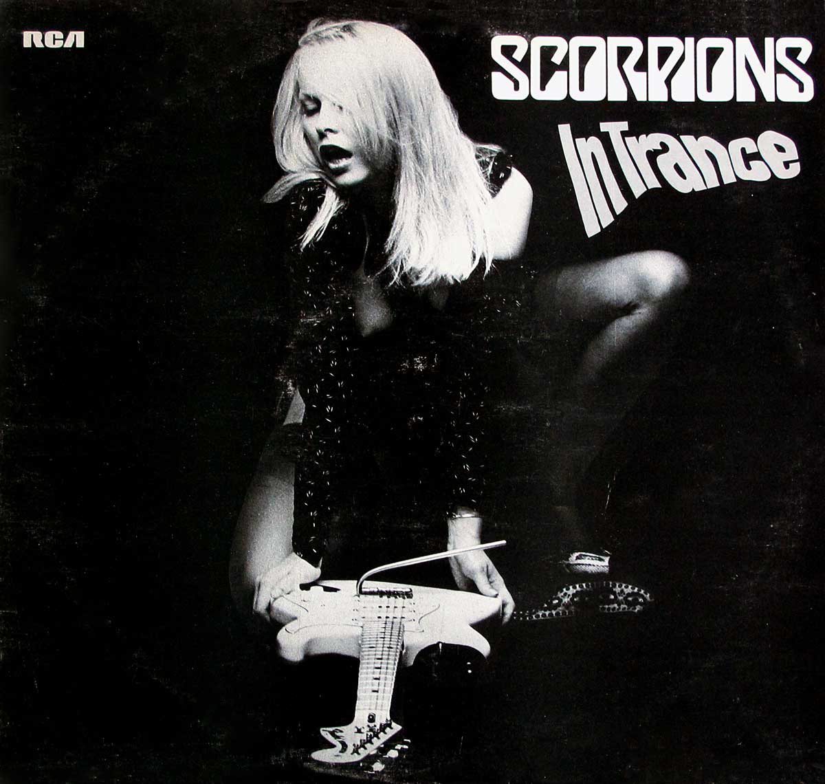 Album cover of Scorpions' In Trance featuring a black-and-white image of a woman with blonde hair crouching, her hand resting on a white electric guitar. She wears dark clothing, and the typography displays the band name Scorpions and album title In Trance in stylized, bold fonts. The RCA logo appears in the top left corner.