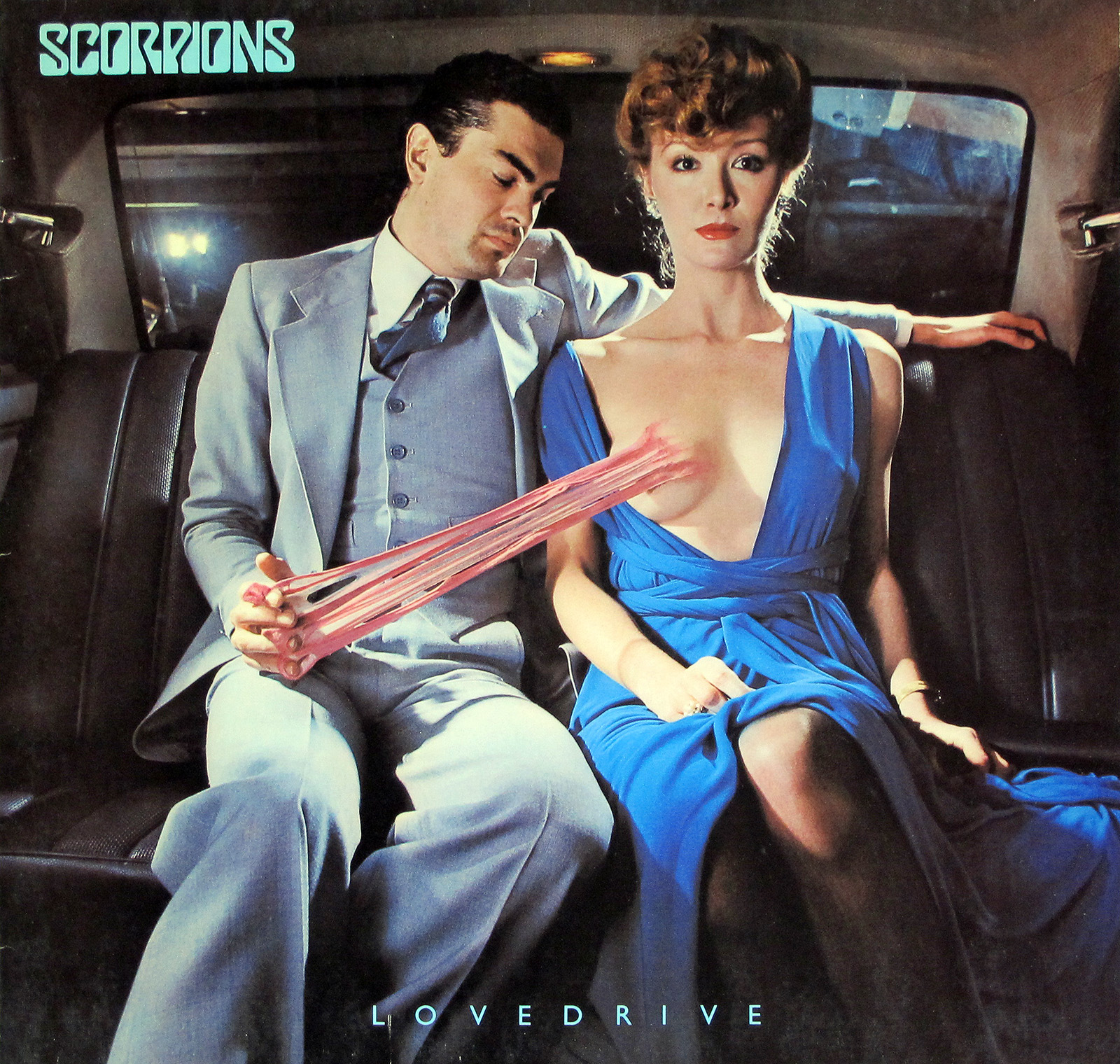 Album cover of Scorpions' Lovedrive German release featuring a man in a light blue suit and a woman in a blue dress seated in a car with pink bubblegum stretching from the man's hand to the woman's exposed breast, designed by Hipgnosis.