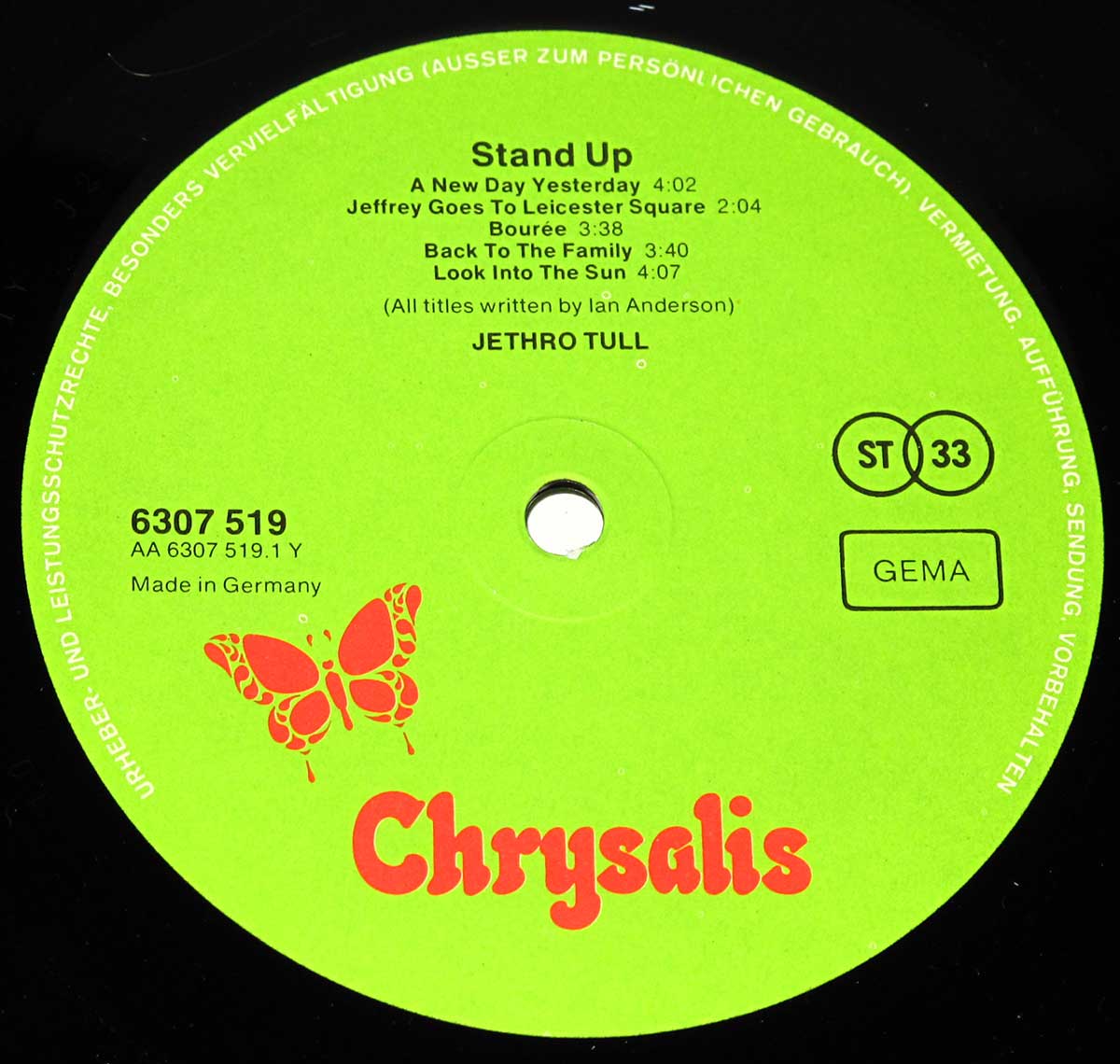 Close-up of Side One record label for Jethro Tull's 1969 'Stand Up' German LP release. The label is lime green with bright red Chrysalis logo and butterfly emblem. The upper half lists the album title 'Stand Up' and tracklist: A New Day Yesterday, Jeffrey Goes to Leicester Square, Bourée, Back to the Family, and Look Into the Sun—all written by Ian Anderson. The band's name appears centered below. Catalog number 6307 519, matrix AA 6307 519.1 Y, and 'Made in Germany' are printed on the left. On the right are symbols ST 33, GEMA, and surrounding copyright text in white along the label’s edge.