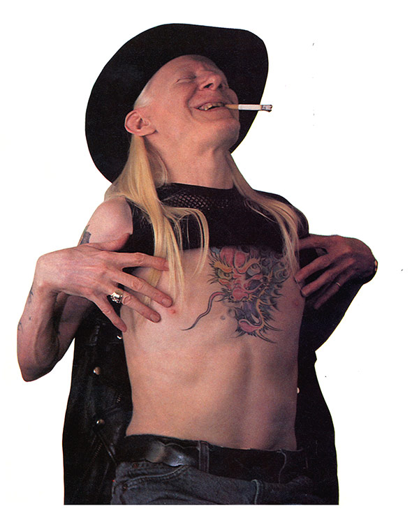 Photo of Johnny Winter showing of his dragon tattoo - https://vinyl-records.nl/johnny-winter/biography/index.html