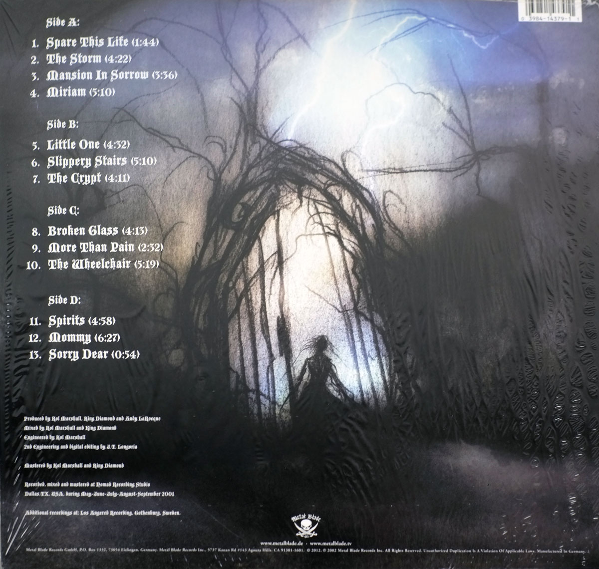Back cover of KING DIAMOND - Abigail II: The Revenge. A dark, eerie landscape features twisted, leafless trees forming an archway. A shadowy figure with long, flowing hair stands in the distance, silhouetted against a faint, ghostly light. The tracklist is displayed on the left, while production credits are printed in small white text at the bottom. The Metal Blade Records logo is present.