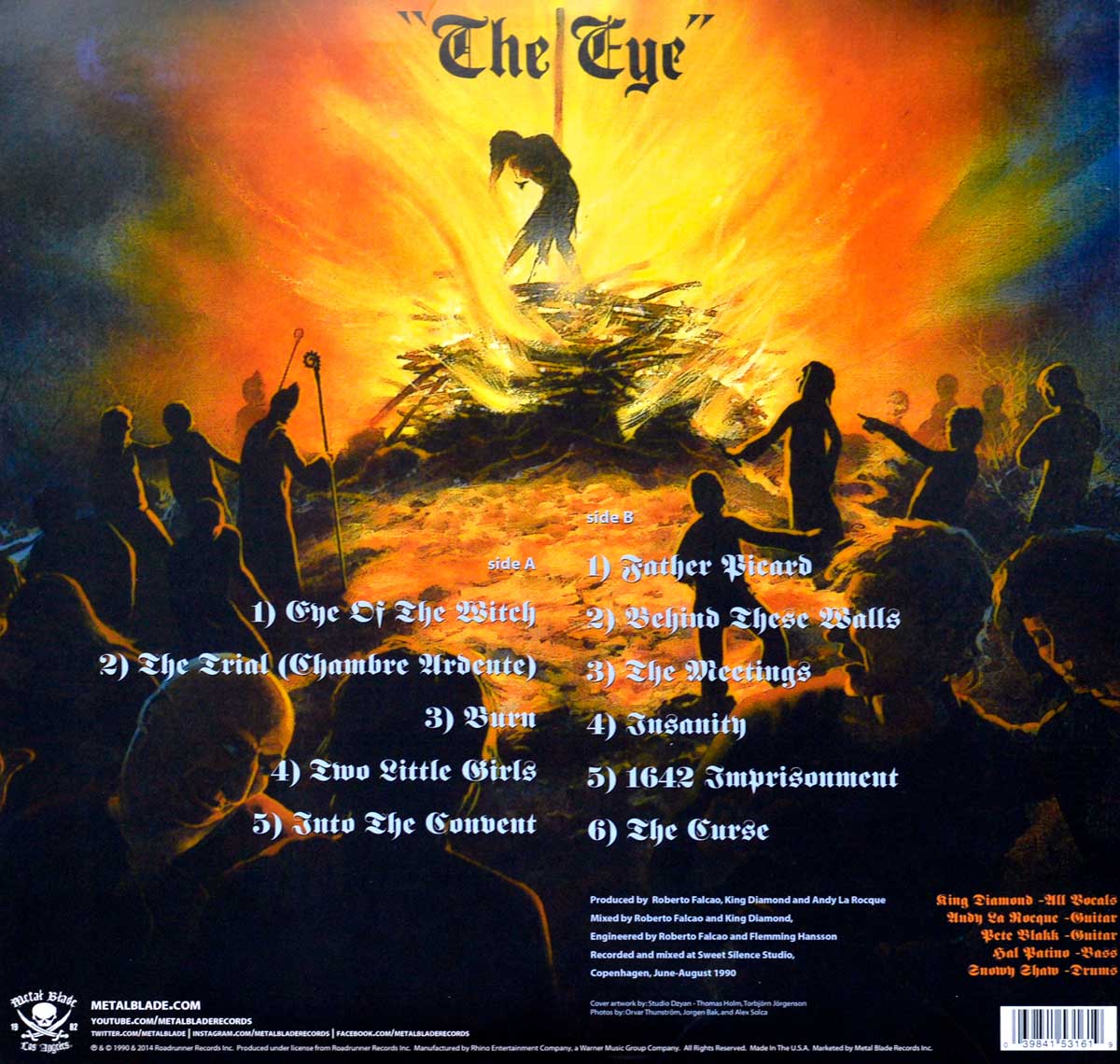 Back cover of King Diamond's 'The Eye' featuring a dramatic scene of a witch burning at the stake, surrounded by dark figures against an intense fiery background.