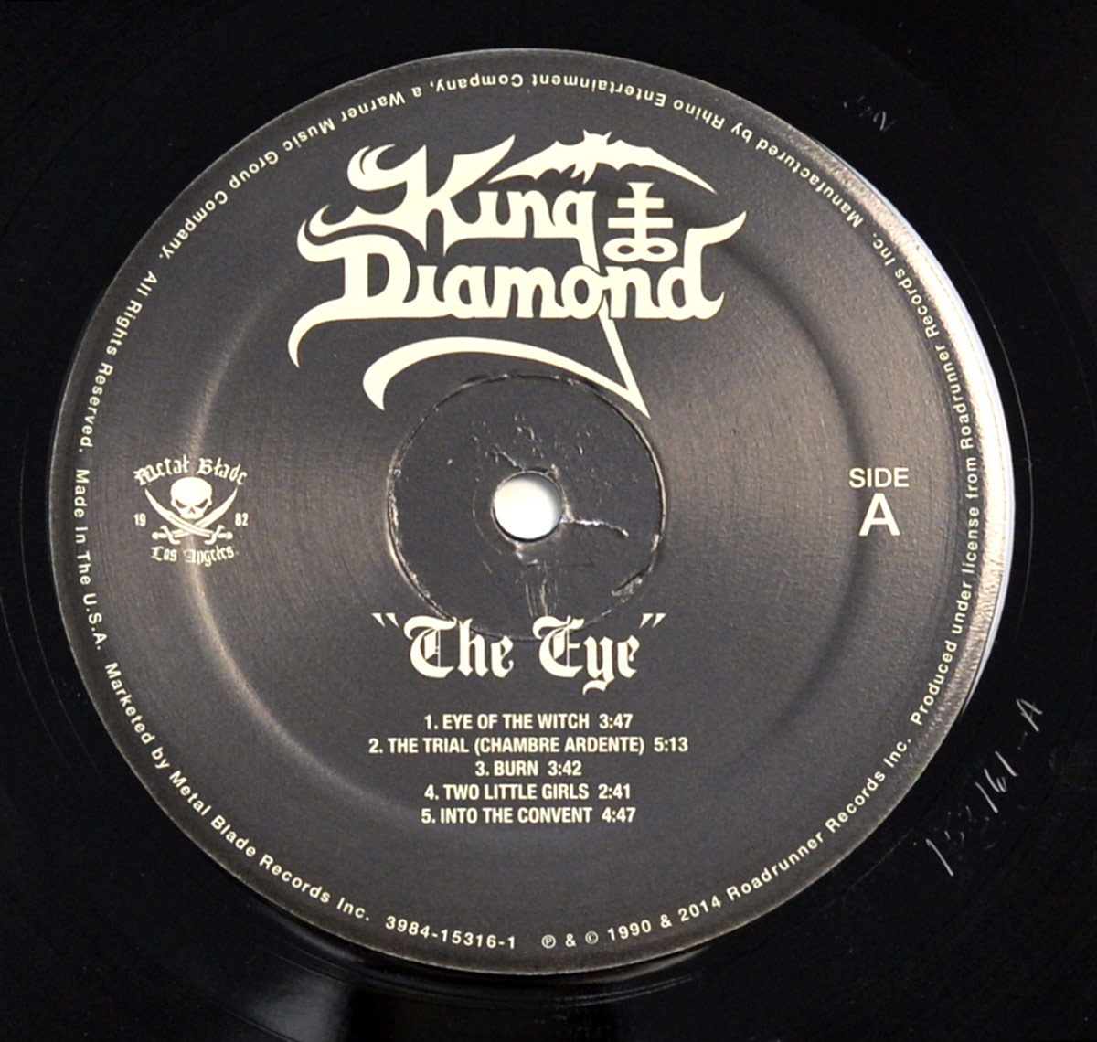 Side A of King Diamond's 'The Eye' vinyl record, featuring a black label with gothic white text, the band's logo, tracklist, and Metal Blade Records branding.