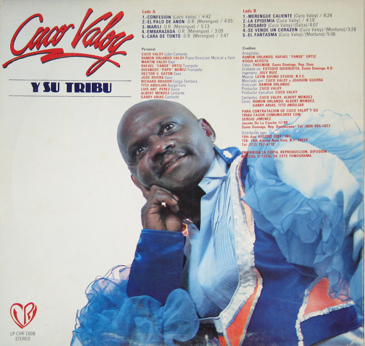 Back cover of 'Cuco Valoy y Su Tribu' vinyl album. Cuco Valoy is shown in an elegant pose, resting his head on his hand while wearing a ruffled blue and white outfit. The background is white, with red and black text listing song titles, credits, and production details. The album's bold red and blue title sits at the top.