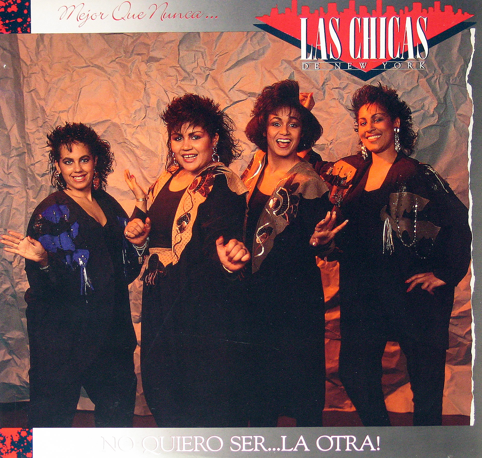 Album cover of Mejor Que Nunca… by Las Chicas de Nueva York featuring the four band members in coordinated black outfits with sequined designs, smiling and posing against a textured backdrop. The album title and band name are prominently displayed, with the subtitle No Quiero Ser… La Otra! at the bottom.