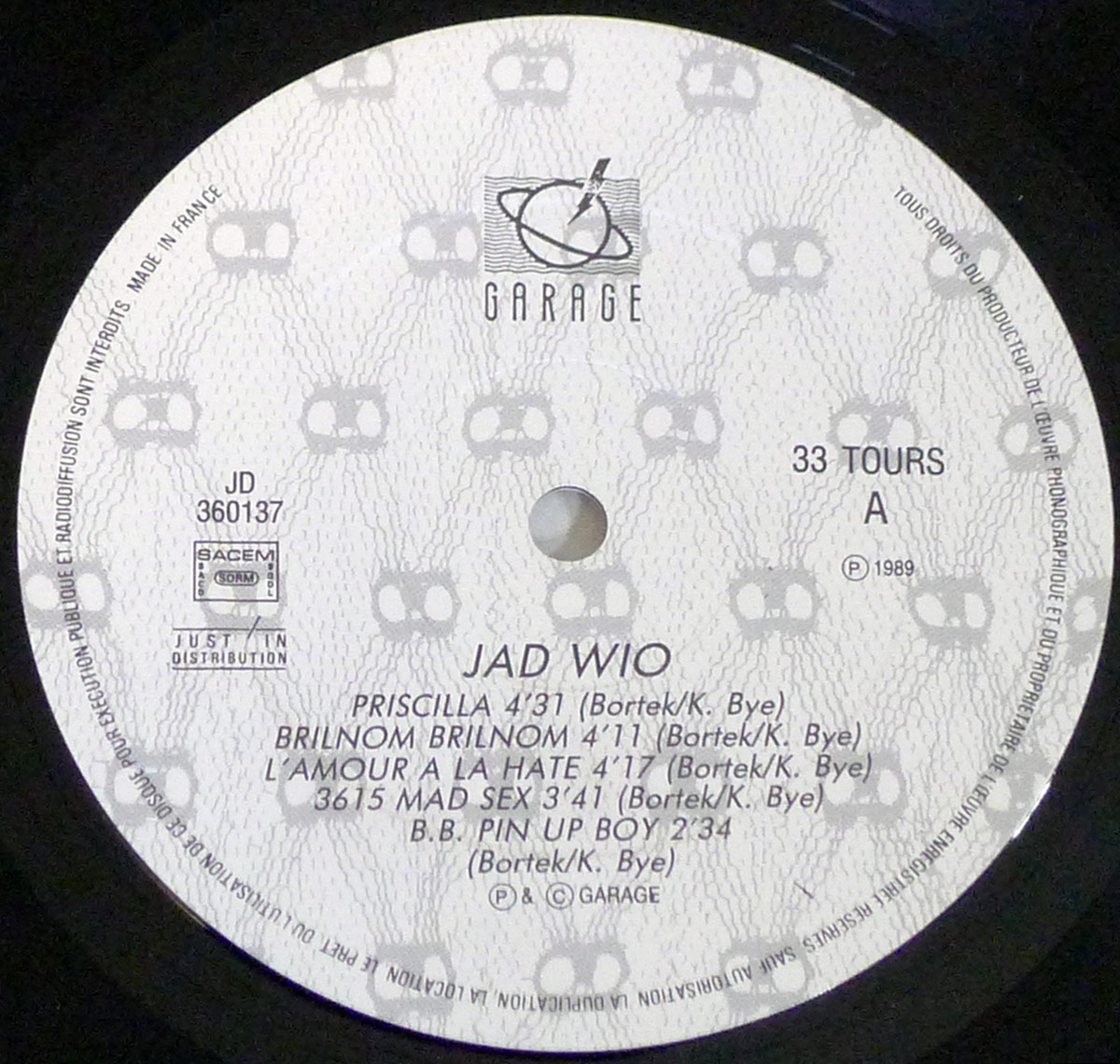 Record label of JAD WIO Contact Side One featuring Garage label logo, SACEM logo, catalog number JD 360137, and tracklist of five songs with credits to Bortek and K. Bye.
