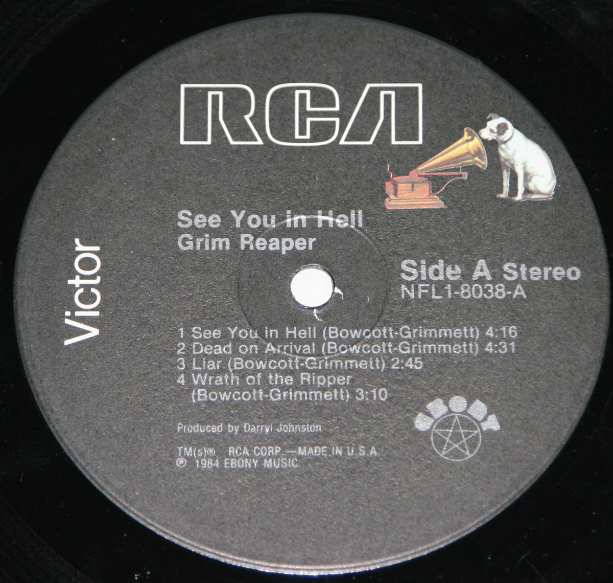 Close-up of the 'See You in Hell' vinyl record label by RCA Victor. The black label features the RCA logo in bold white letters, with the classic Nipper the dog listening to a gramophone. Below, the album title and Grim Reaper’s name appear in silver text, along with track details, production credits, and the Ebony Records logo. The catalog number NFL1-8038-A is printed on the right side.