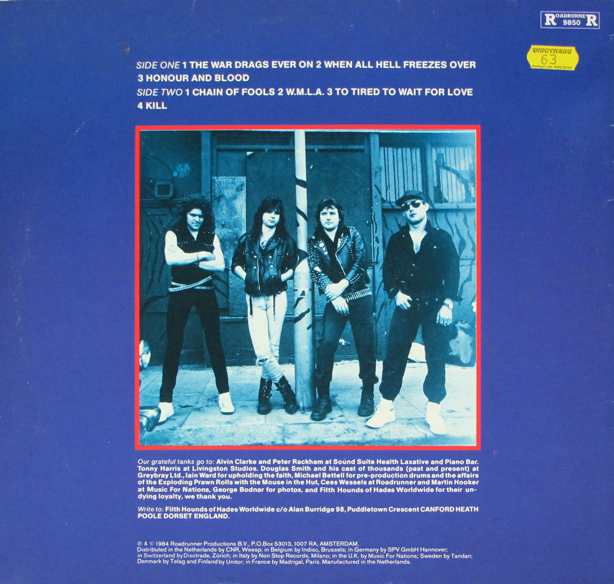 Back cover of the Roadrunner Records 12-inch vinyl LP album TANK - Honour and Blood. The layout features a bold blue background with the full tracklist for Side One and Side Two printed in white at the top. Below, framed in a red border, is a monochrome blue-tinted photo of the band Tank standing casually in front of a worn urban wall. The four members wear leather jackets and rock attire, with confident postures. Additional liner notes and credits, including thanks to engineers and contributors, are printed at the bottom in white text along with copyright details and distribution information.