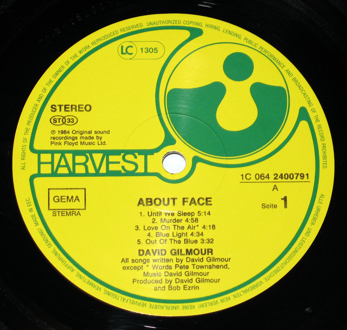 Yellow and green Harvest Records label for David Gilmour’s About Face, featuring the Harvest logo on the right, copyright information around the edge, catalog numbers LC 1305 and 1C 064-2400791, GEMA STEMRA designation, and production credits for David Gilmour and Bob Ezrin