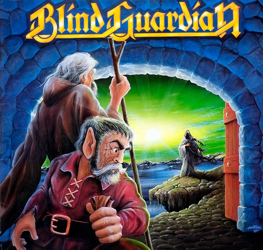 Album cover of Blind Guardian's Follow the Blind, featuring two hooded figures in a stone archway watching a robed figure walk across a rocky path under a glowing green sky. The scene captures a mystical, fantasy-inspired atmosphere.