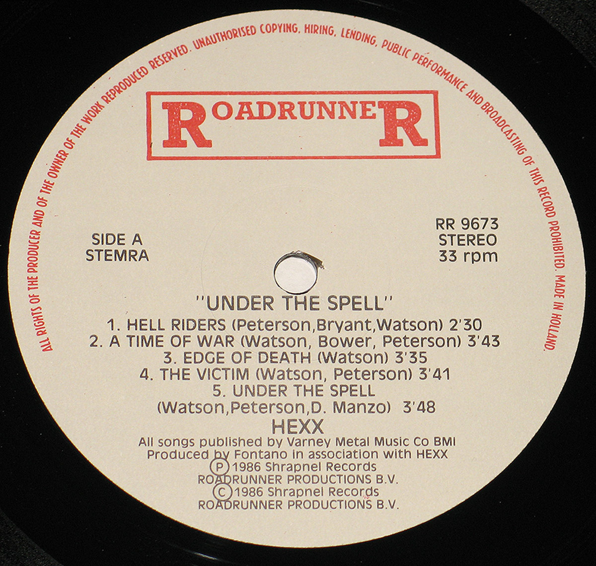 Close-up of the record label for HEXX - Under the Spell, featuring the Roadrunner Records logo, tracklist for Side A, and production details on a beige background.