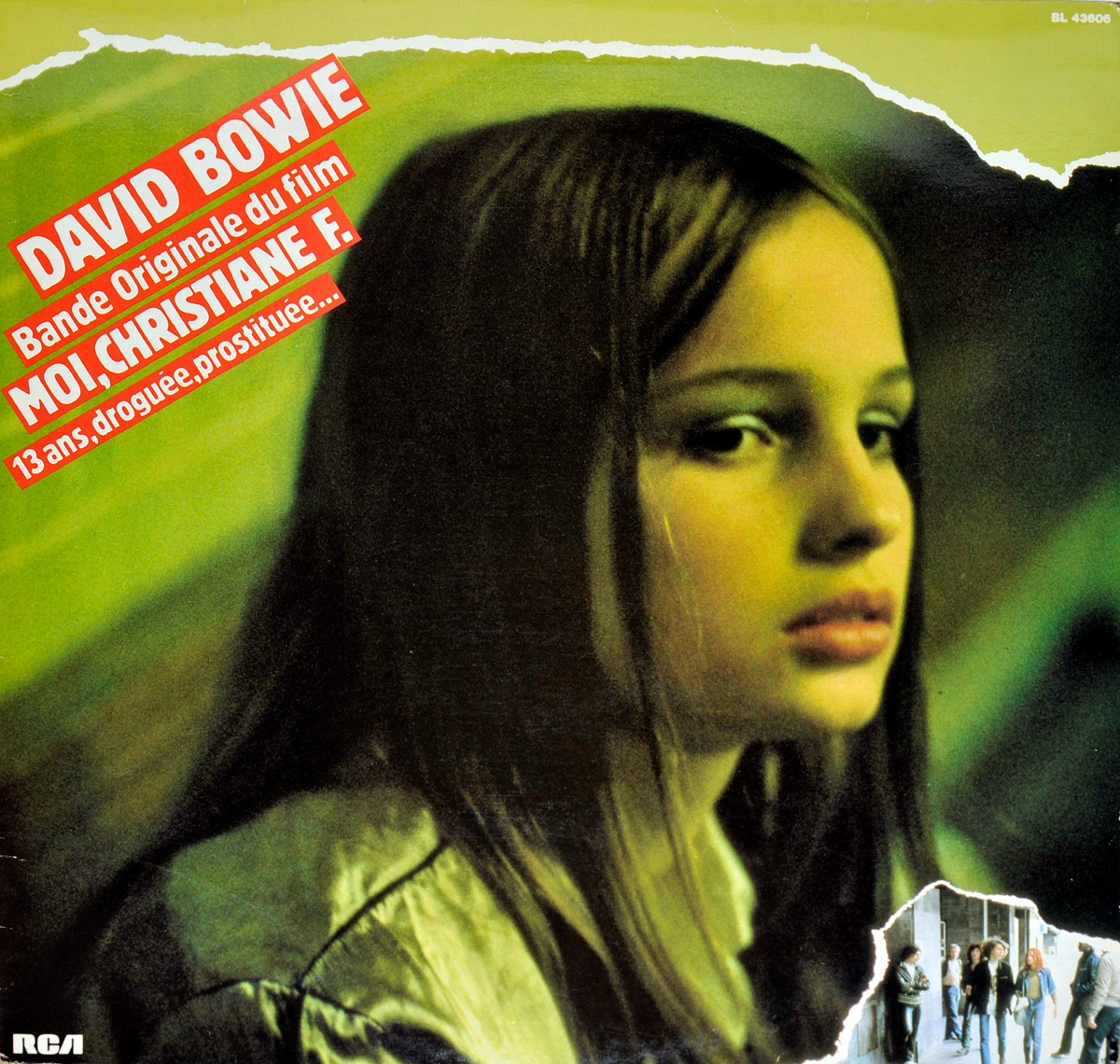 Album cover of David Bowie’s soundtrack for Moi, Christiane F. featuring a close-up portrait of a melancholic young girl with a distant gaze, tinted in greenish hues. A torn-paper effect in the bottom right corner reveals an inset image of a group of teenagers standing near a train station, emphasizing the film’s dark themes of youth and addiction.