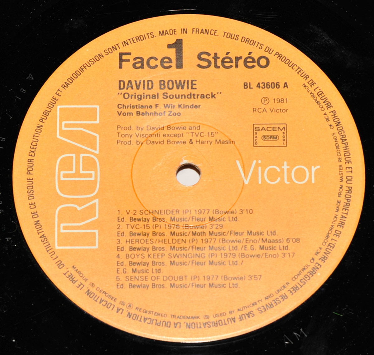 Orange RCA Victor record label for David Bowie's Original Soundtrack to Christiane F. – Wir Kinder vom Bahnhof Zoo (1981). The label features the RCA logo on the left, 'Victor' branding on the right, and tracklist details for Side 1, including 'V-2 Schneider,' 'TVC-15,' and 'Heroes/Helden.' Production credits list David Bowie, Tony Visconti, and Harry Maslin.