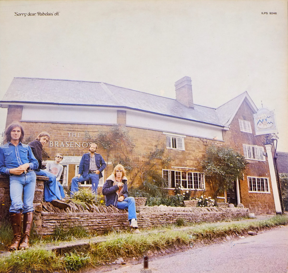 Back cover of Fairport Convention's 'Nine' album featuring the band seated in front of The Brasenose pub in Cropredy, England, dressed in casual 1970s attire. The image shows a rustic brick building with white-trim windows, a hanging pub sign, and the group positioned on a low stone wall and grass verge.