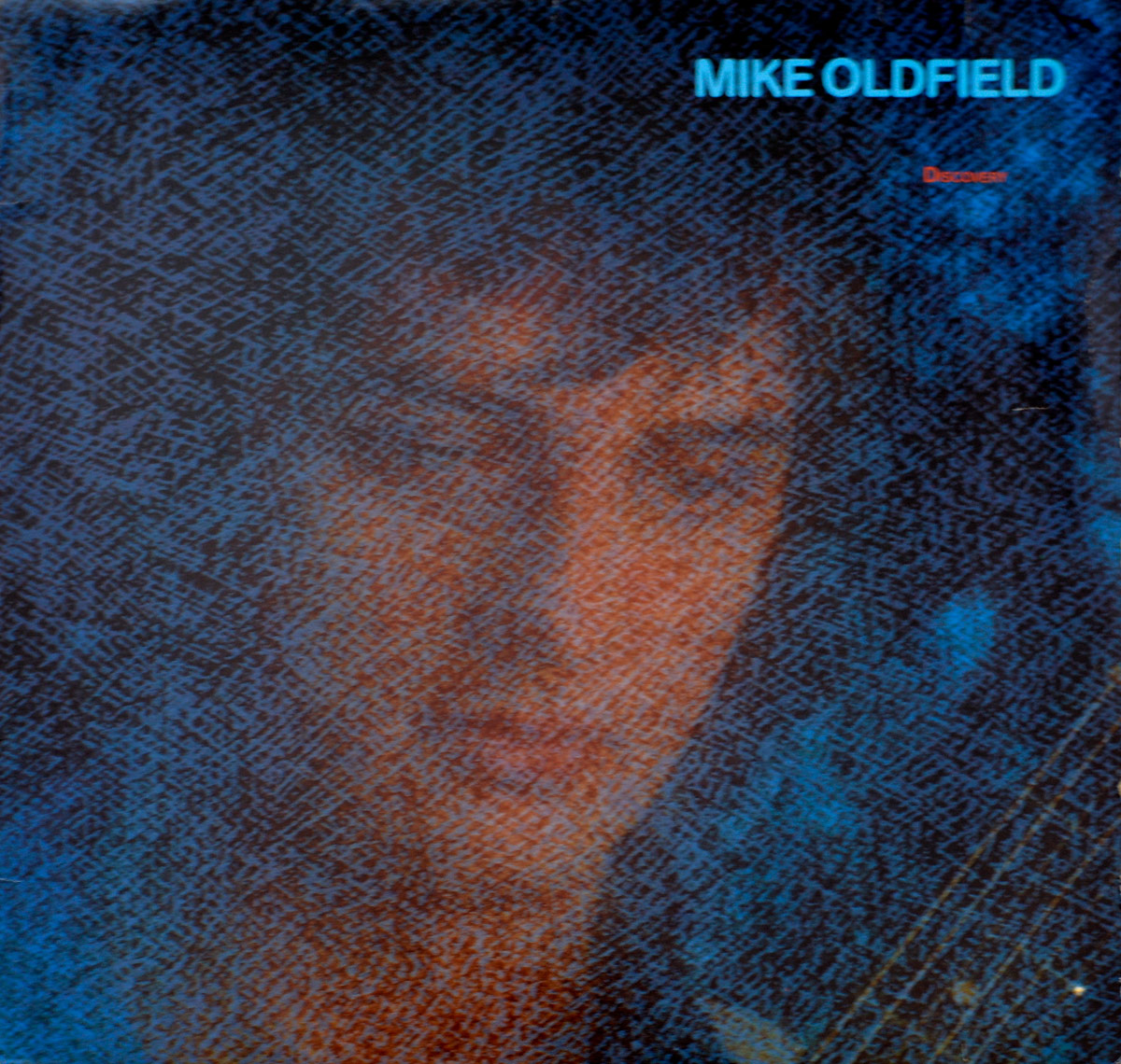 MIKE OLDFIELD - Discovery album front cover: a soft-focus portrait of Mike Oldfield behind a textured blue-and-orange overlay, with album and artist names in minimalist typeface.