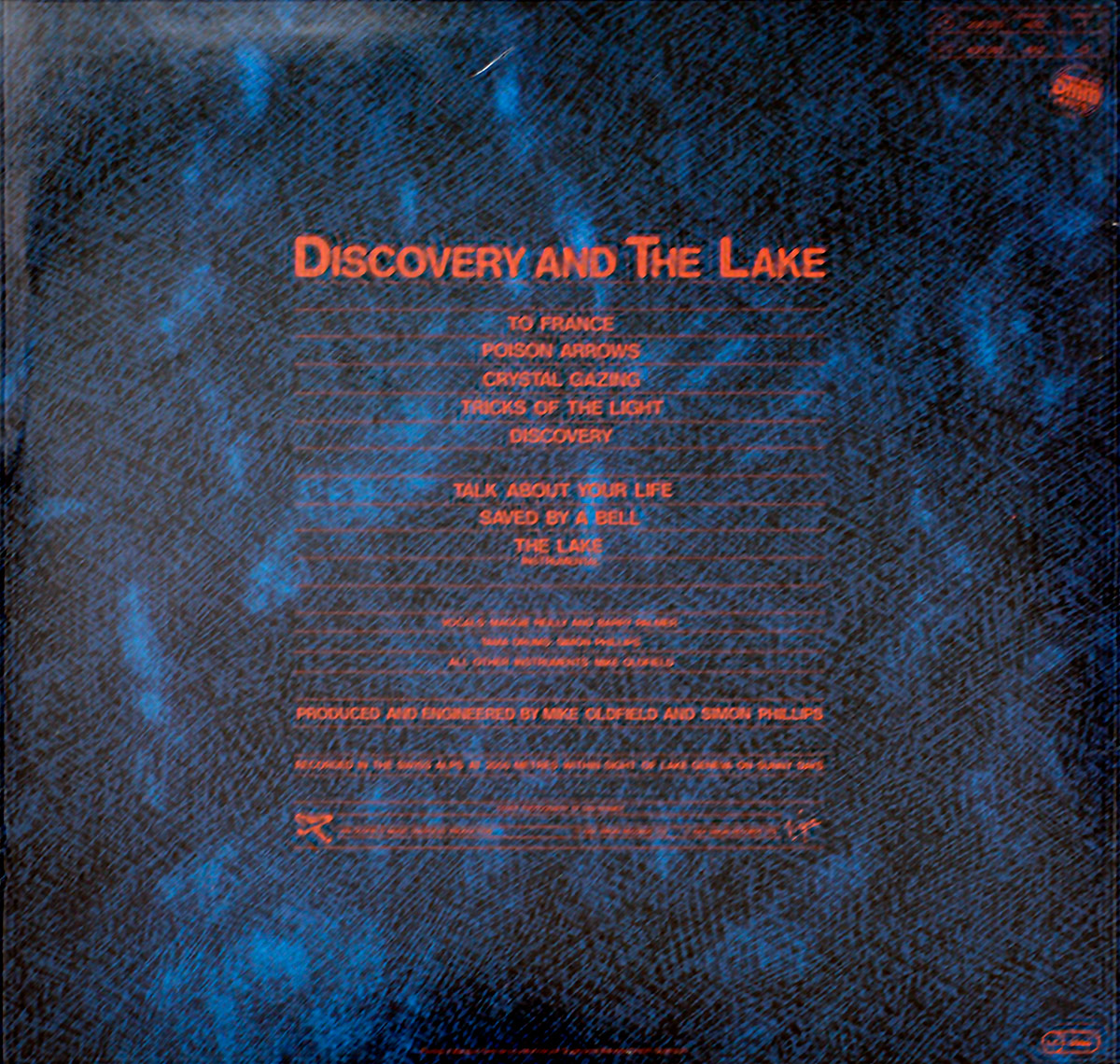 MIKE OLDFIELD - Discovery back cover: blue textured background with red text listing track titles and production credits. Stylized text layout with ambient aesthetic.
