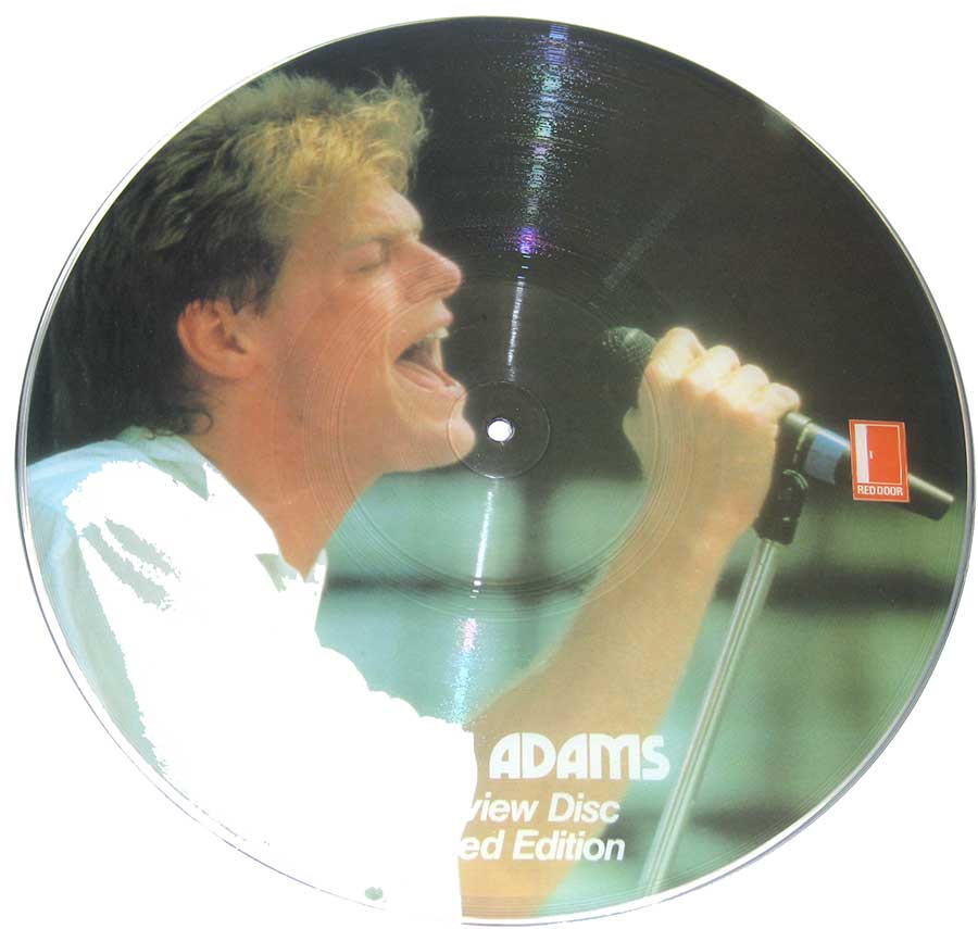 Bryan Adams singing passionately into a microphone, close-up photo on vinyl picture disc with 'Red Door' logo, 1983 limited edition interview disc.