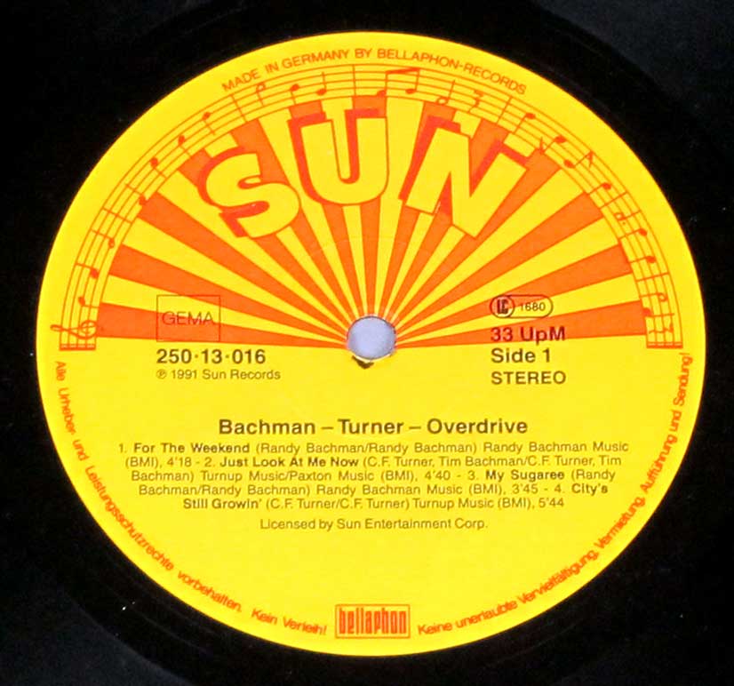 Close-up of a vinyl record label for Bachman-Turner Overdrive, featuring the iconic yellow Sun Records design with a red and orange sunburst and musical notes, listing Side 1 tracks, song details, and production credits. Manufactured in Germany by Bellaphon Records.