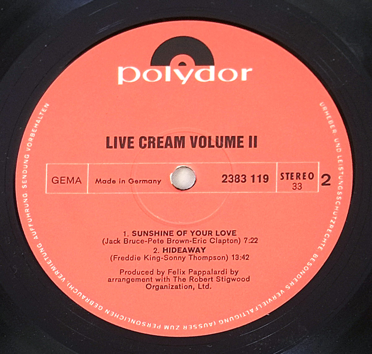 Vinyl record label of 'Live Cream Volume II' by Cream, released by Polydor. The label is red with black text and features the Polydor logo at the top. The album title, 'Live Cream Volume II,' is printed in bold uppercase letters, followed by the track listings for Side Two. This side includes the songs 'Sunshine of Your Love' (7:22) and 'Hideaway' (13:42), credited to Jack Bruce, Pete Brown, Eric Clapton, Freddie King, and Sonny Thompson. Additional details such as the catalog number (2383 119), stereo format, and production credits for Felix Pappalardi are also present. The label indicates that the record was made in Germany and contains copyright protection text around the edge.