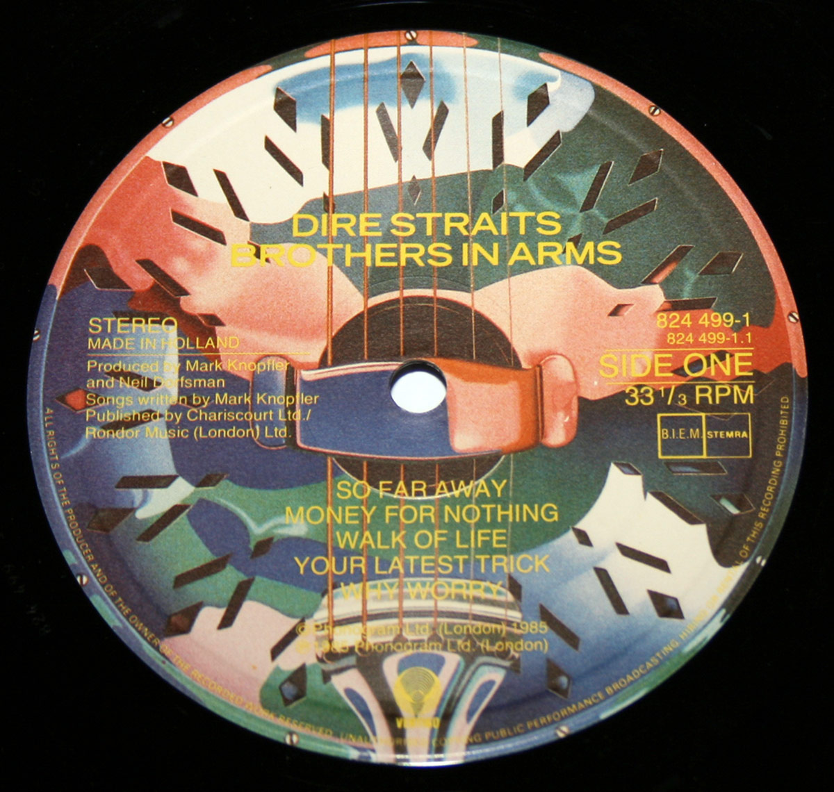 Close-up of Side One label from Dire Straits' Brothers in Arms Holland vinyl pressing, featuring colorful resonator guitar artwork with tracklist and production credits.