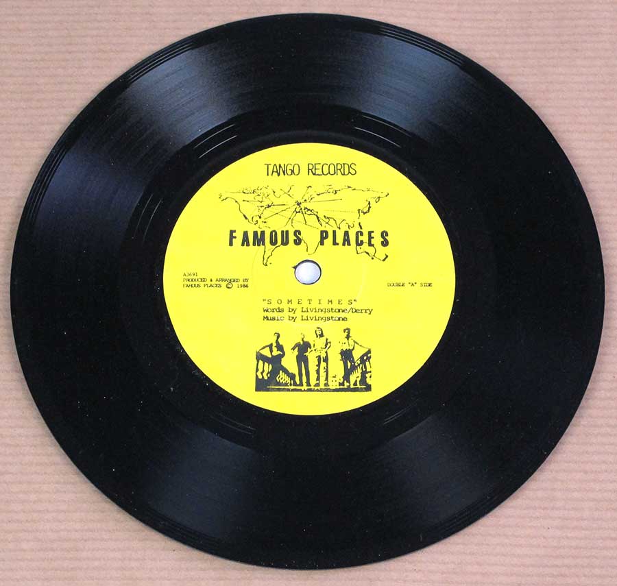 ‘Yellow record label of Famous Places’ vinyl release on Tango Records, featuring the band’s name with a world map design above. Includes the track title “Sometimes,” credited to Livingstone/Derry for words and Livingstone for music. Label notes it is a “Double ‘A’ Side” and features a silhouette illustration of the band at the bottom. Production credited to Famous Places ©1986.’