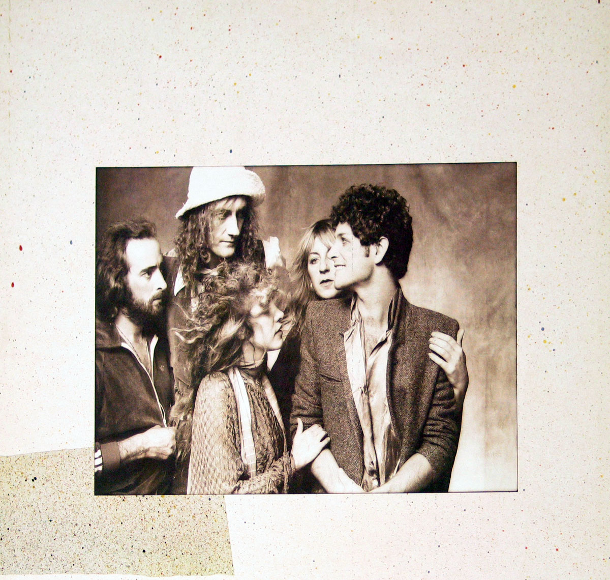 Fleetwood Mac's Tusk album sleeve featuring a sepia-toned group portrait of the five band members—Mick Fleetwood, John McVie, Stevie Nicks, Christine McVie, and Lindsey Buckingham—closely gathered in an intimate and candid moment.