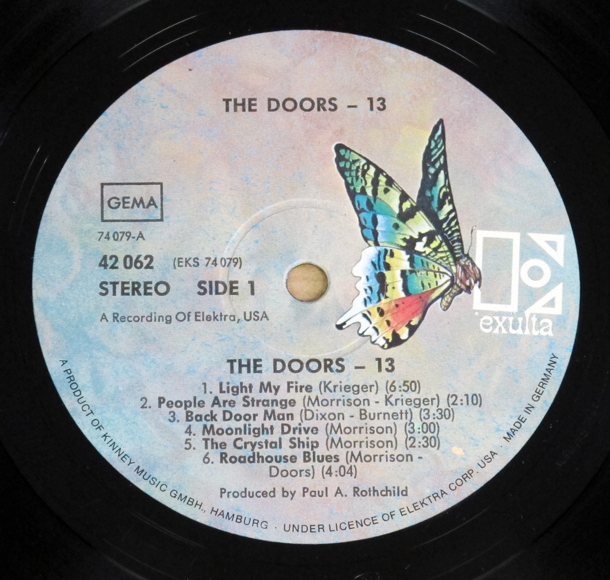 Record label of The Doors 13 album Side 1, featuring a multicolored butterfly on a light marbled background, track listing in black text, and Elektra and GEMA logos.