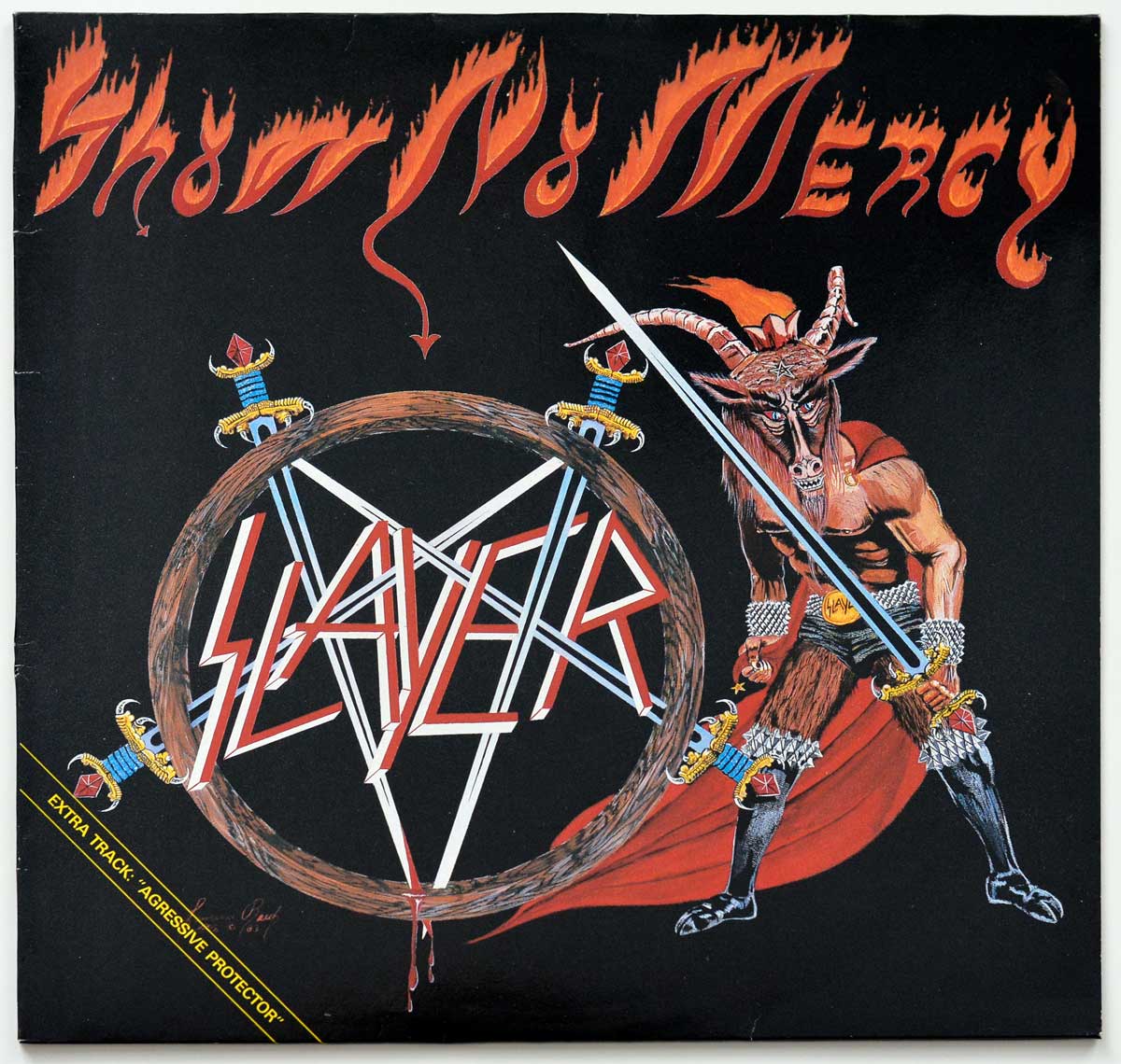 Front cover of Slayer's Show No Mercy Netherlands pressing, featuring demonic goat-warrior with flaming sword, pentagram, and bold Slayer logo inside circle of swords and dripping blood.