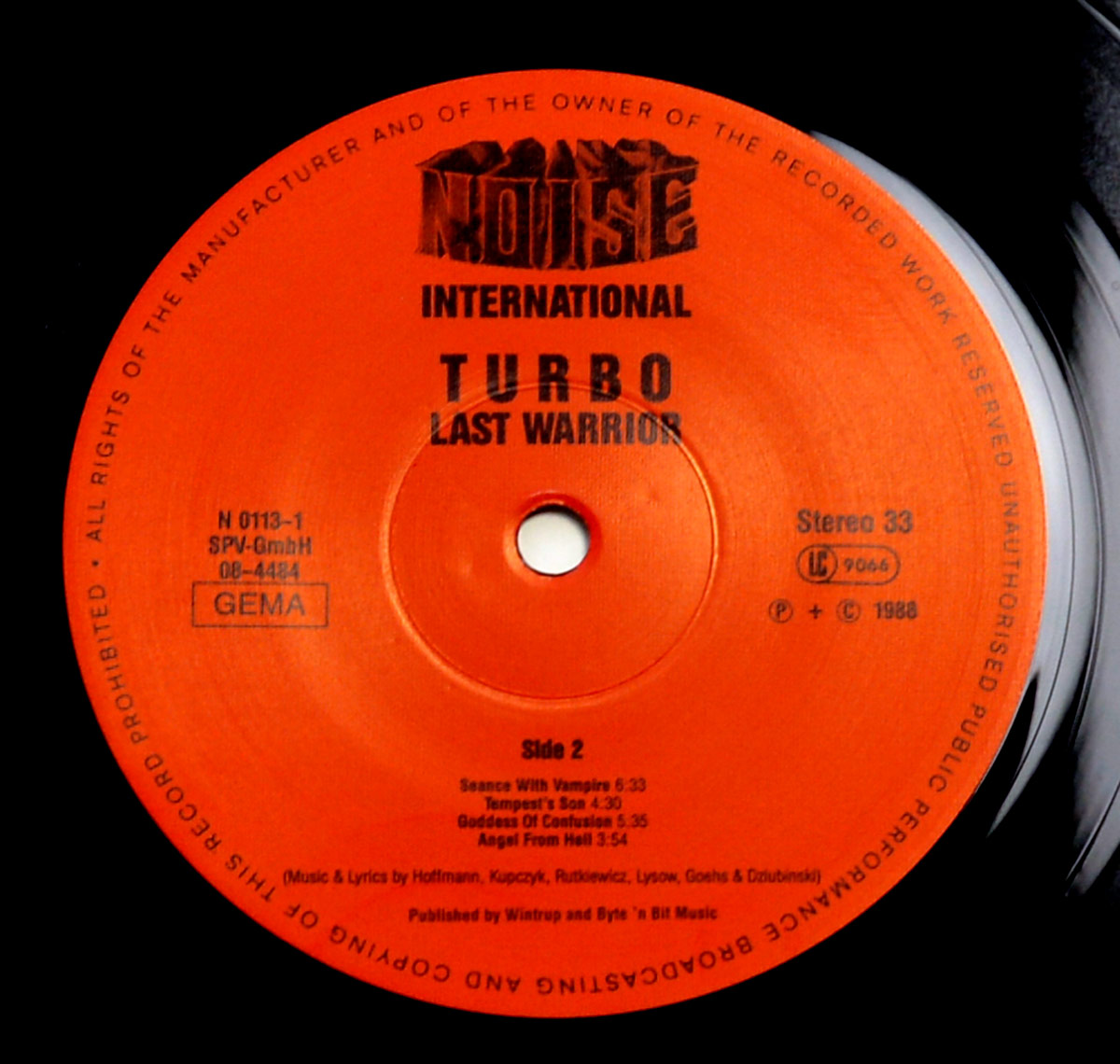 Side Two label of TURBO's Last Warrior LP, Noise International N 0113-1, showing tracks and credits printed in black on an orange vinyl label