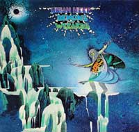 Cover of Uriah Heep's Demons and Wizards album featuring a mystical figure on crystalline cliffs under a starry sky, wielding a magical staff. Artwork by Roger Dean