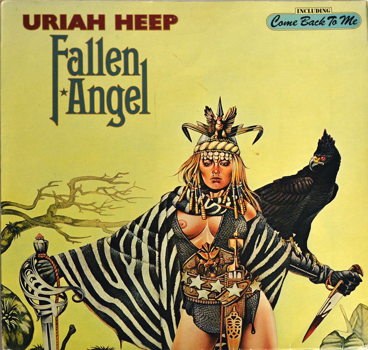 Front cover artwork of Uriah Heep’s 1978 German LP Fallen Angel. The illustration depicts a striking female warrior dressed in zebra-striped cloak and ornate armor, holding a sword in one hand and a dagger in the other. Her headdress is decorated with beads, feathers, and animal motifs, while a black bird of prey perches on her shoulder. The background is pale yellow with sparse twisted trees, adding an eerie fantasy setting. Album title Fallen Angel is in stylized lettering, with a small box noting inclusion of the track Come Back To Me.